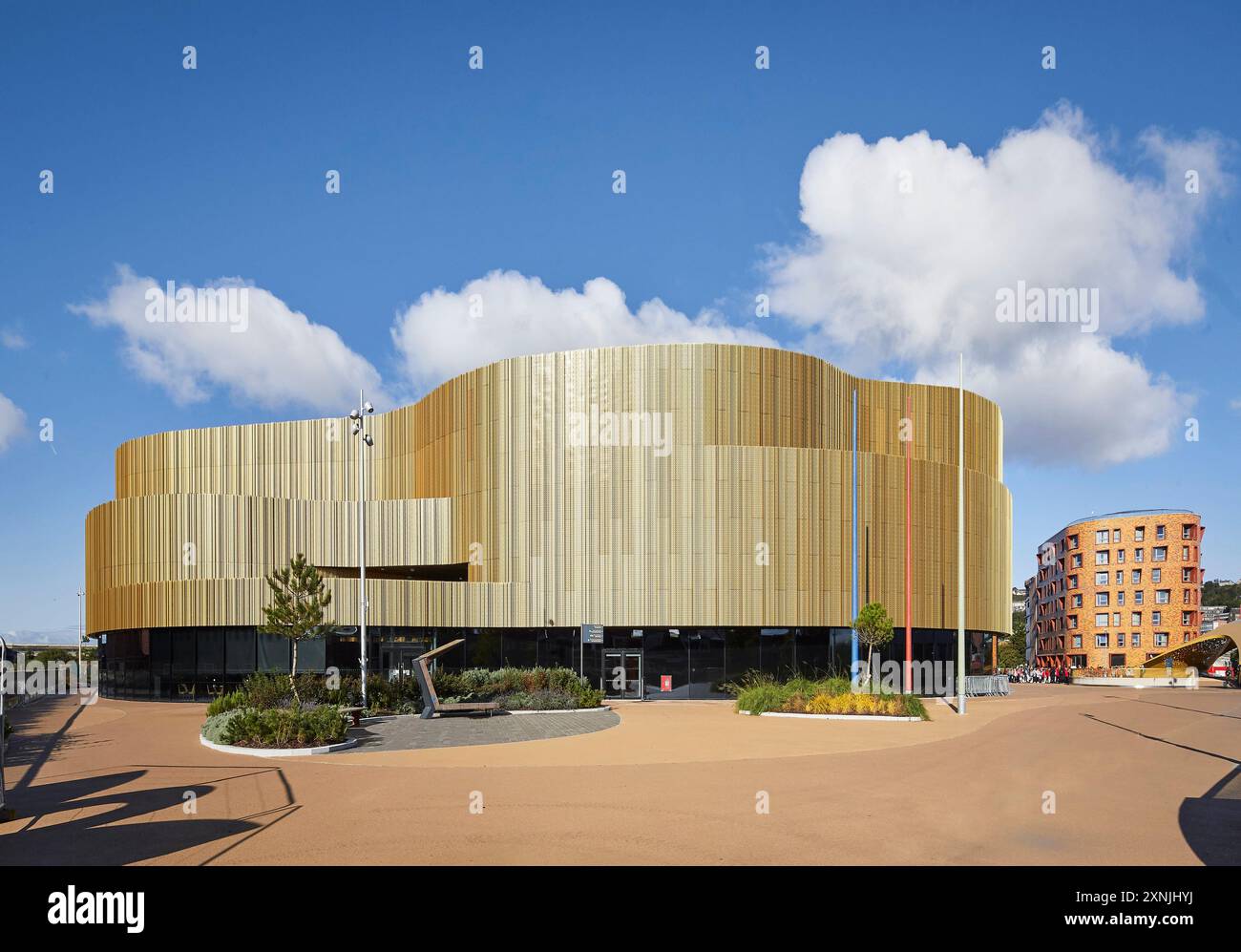 Espace public paysager et aréna extérieur incurvé. Swansea Arena et Copr Bay Bridge, Swansea, Royaume-Uni. Architecte : acme, 2024. Banque D'Images