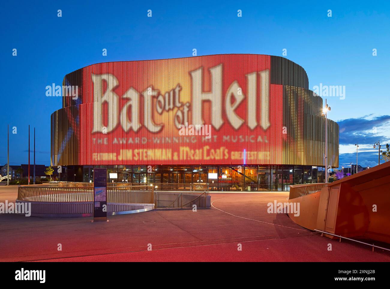 Façade extérieure avec éclairage LED au crépuscule. Swansea Arena et Copr Bay Bridge, Swansea, Royaume-Uni. Architecte : acme, 2024. Banque D'Images