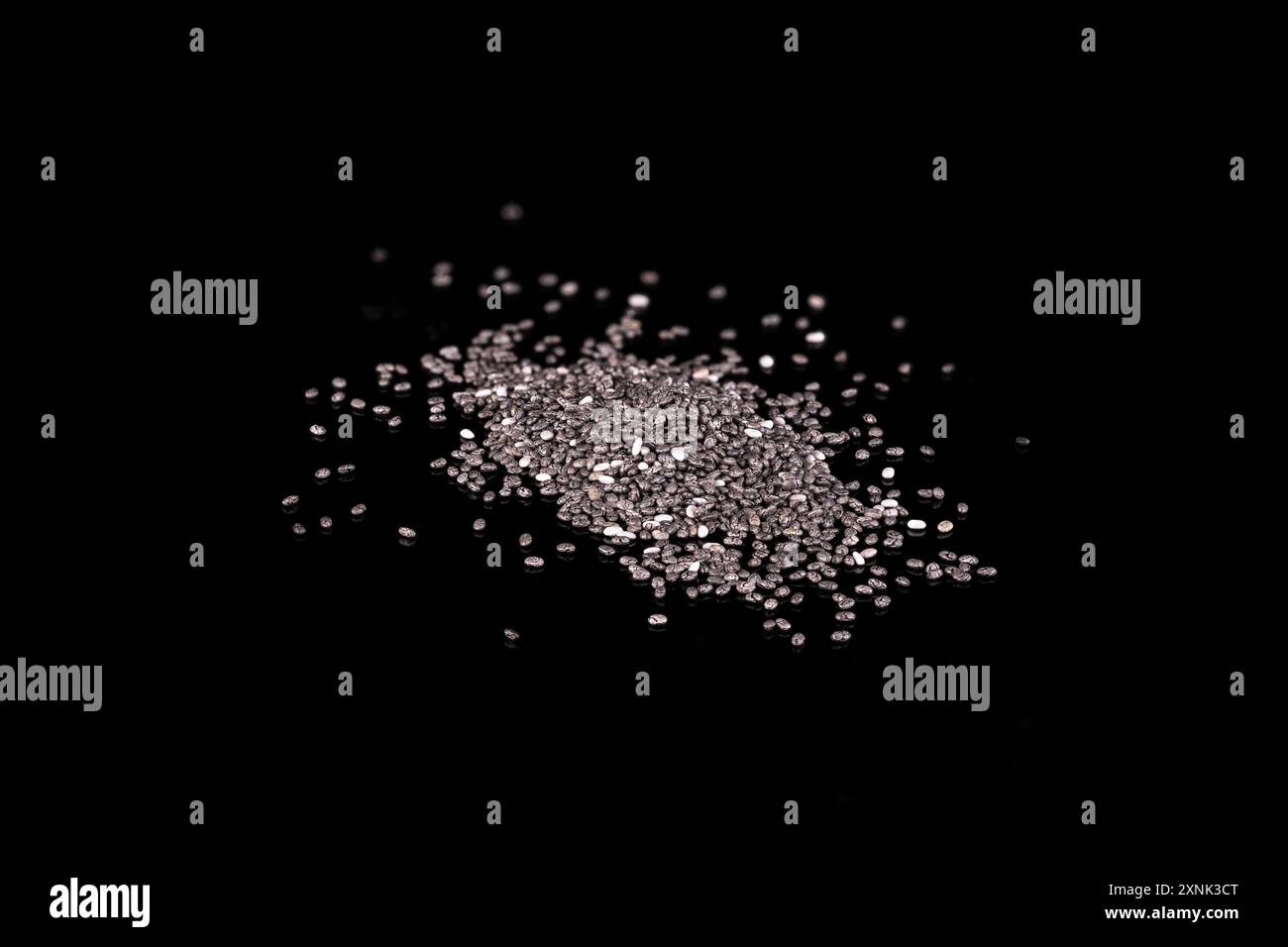 graines de chia isolées sur fond noir Banque D'Images