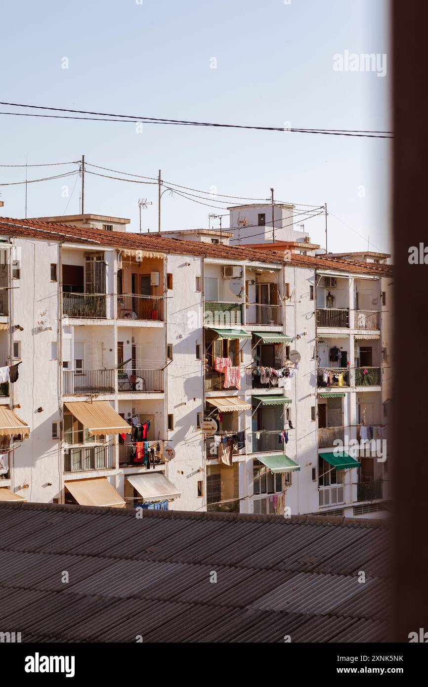 Bâtiments de plusieurs étages avec auvents colorés et vêtements suspendus aux balcons, reflétant l'esprit animé d'une communauté de pêcheurs. Banque D'Images