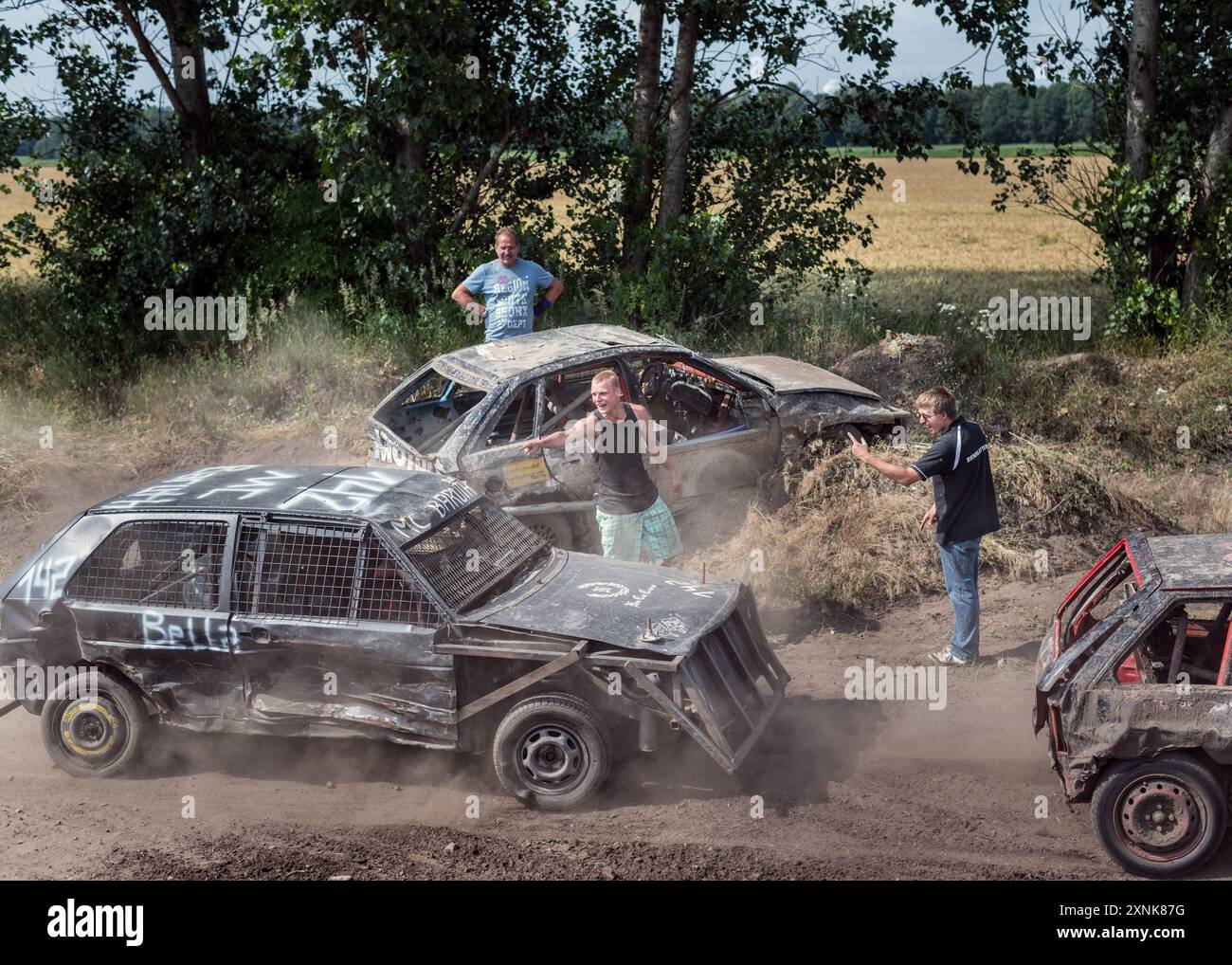 Événement passionnant de derby de démolition mettant en vedette des véhicules endommagés et des participants énergiques, soulignant le frisson et le chaos des courses de stock-cars dans un environnement rural. Banque D'Images