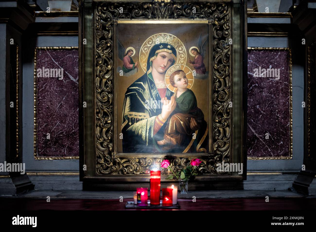 Peinture de Marie et d'enfant bougies votives Templo de San Felipe Neri Mexico // MEXICO CITY, Mexique — Une petite alcôve expose une peinture de Marie et d'enfant avec des bougies votives allumées au premier plan au Templo de San Felipe Neri (église Saint Philippe Neri). L'église est située dans le centre historique de Mexico et est connue pour son architecture de style baroque et ses pierres élaborées. Templo de San Felipe Neri est un site religieux important dans le paysage architectural colonial de la capitale. L'église reflète les profondes traditions catholiques qui ont façonné la religion et le culte mexicains Banque D'Images