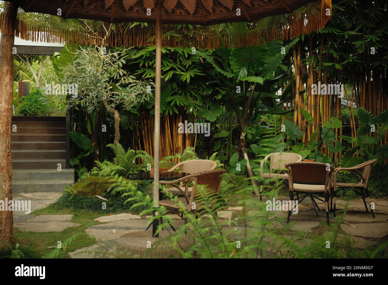 Ubud, Bali, Indonésie - 9 juillet 2024 : architecture design extérieur confortable d'un café avec mobilier d'extérieur dans la cour arrière, avec des plantes tropicales a Banque D'Images
