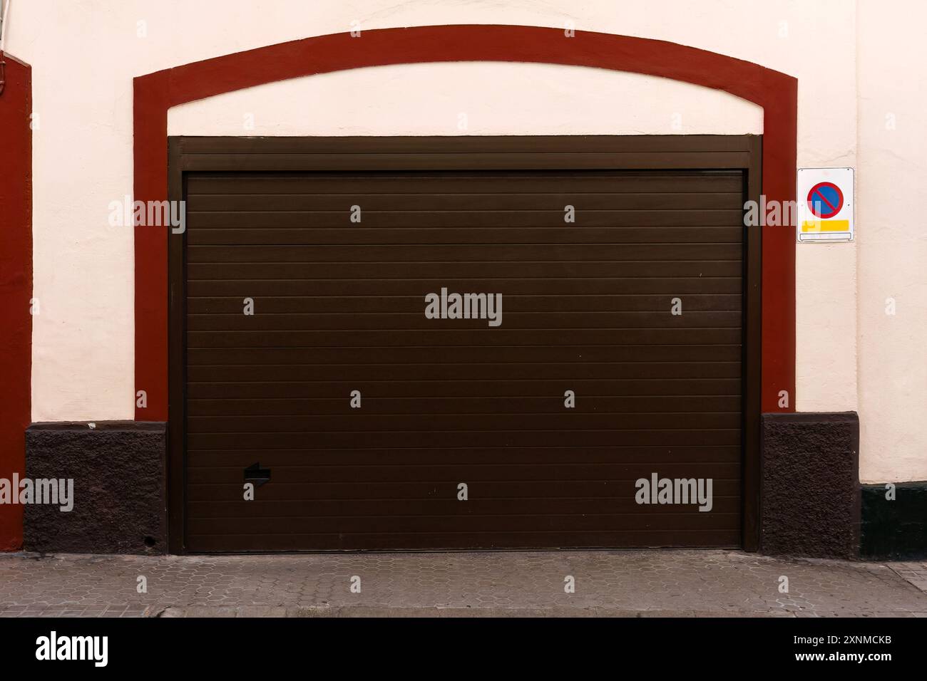 Porte de garage brune fermée avec garniture rouge et pas de panneau de stationnement Banque D'Images