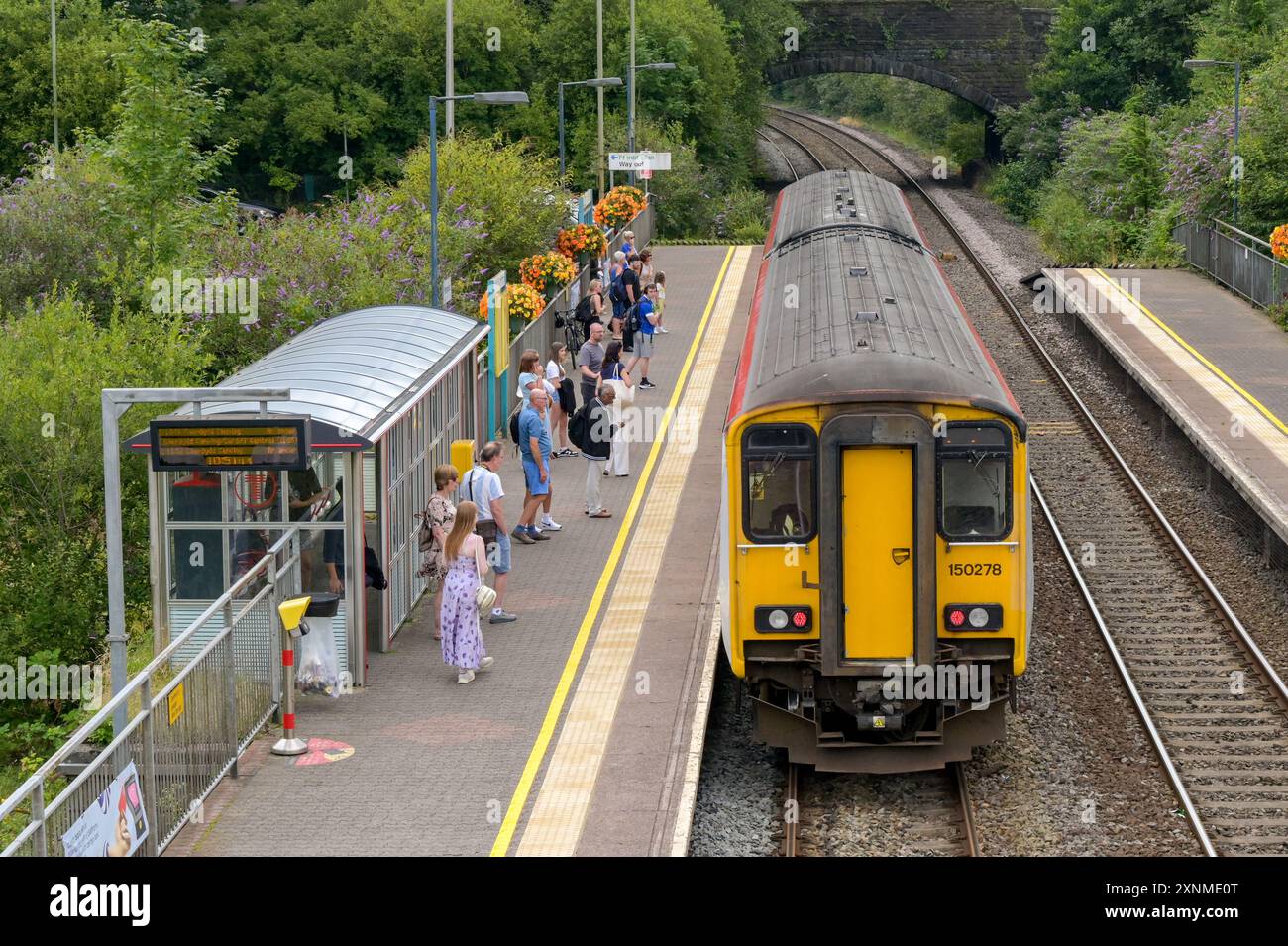 Pontyclun, pays de Galles, Royaume-Uni. - 31 juillet 2024 : personnes prenant un train de banlieue diesel classe 150 Sprinter à la gare du village de Pontyclun Banque D'Images