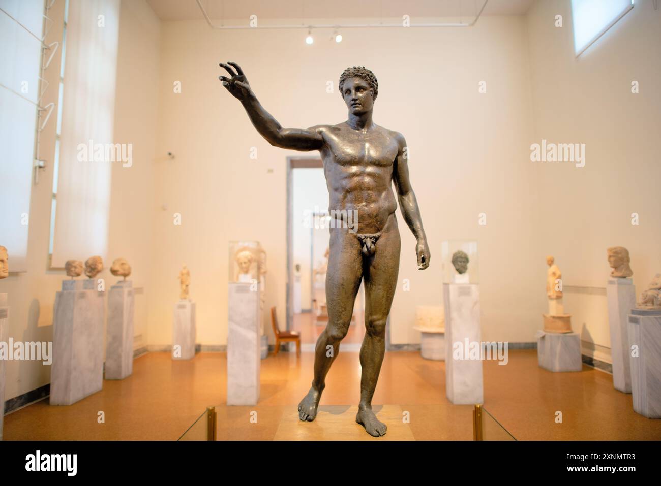 ATHÈNES, Grèce — L'Ephèbe d'Antikythère, également connu sous le nom de Jeunesse d'Antikythère, est une sculpture en bronze exposée au Musée archéologique national d'Athènes. Récupérée du naufrage d'Antikythère, cette statue remonte à la fin du IVe siècle av. J.-C. et représente une figure masculine jeune idéalisée, mettant en valeur l'importance artistique et culturelle de la période hellénistique. L'Ephèbe d'Antikythère est connu pour sa représentation réaliste et son artisanat complexe, soulignant l'excellence des sculpteurs grecs antiques. Banque D'Images