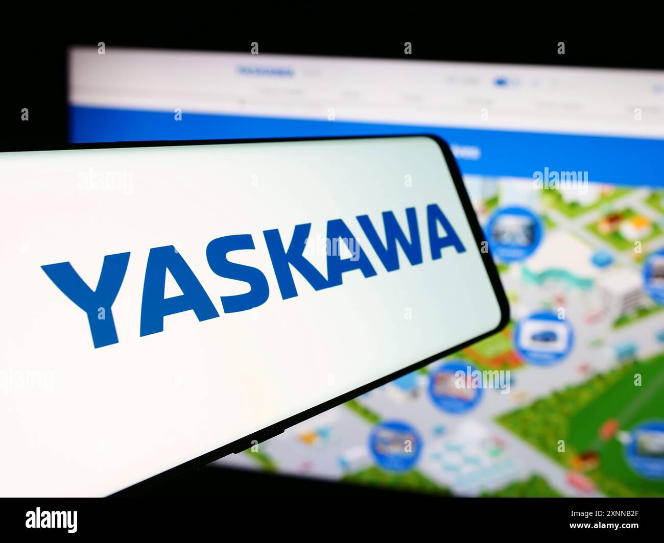 Téléphone portable avec le logo de la société japonaise Yaskawa Electric Corporation devant le site Web de l'entreprise. Mettez l'accent sur le centre-gauche de l'écran du téléphone. Banque D'Images