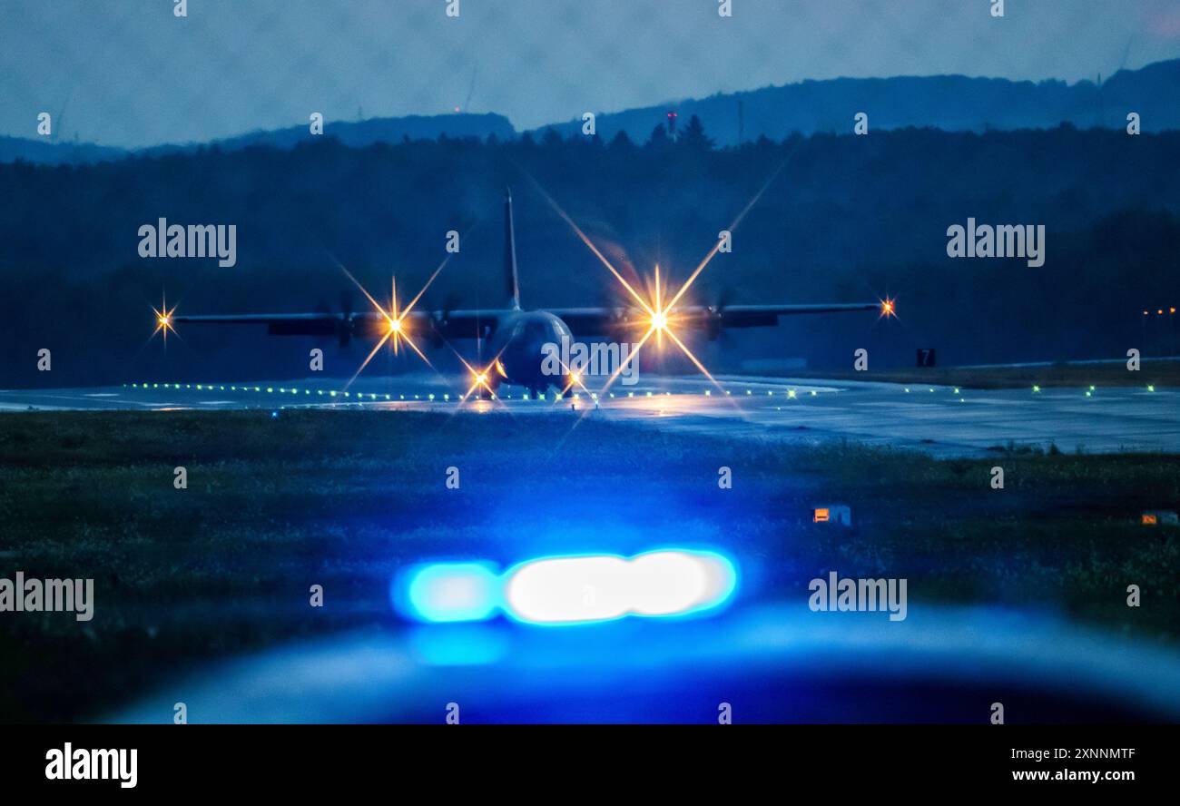 Miesenbach, Allemagne. 01 août 2024. Un avion militaire américain se rend en taxi à sa position de stationnement après avoir atterri à la base aérienne de Ramstein, tandis qu'une voiture de police avec des feux clignotants passe devant. La base aérienne de Ramstein est un aérodrome militaire de la United States Air Force, le quartier général des United States Air Forces en Europe. Crédit : Andreas Arnold/dpa/Alamy Live News Banque D'Images