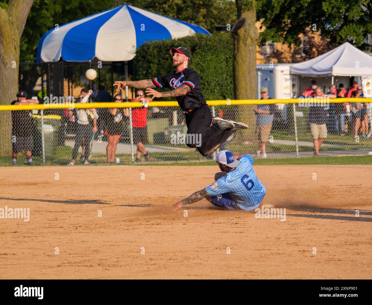 Un joueur de terrain échappe à un Baserunner tentant de rompre un double jeu lors d'un match de softball de 16 pouces, qui est populaire dans la région de Chicago. Banque D'Images