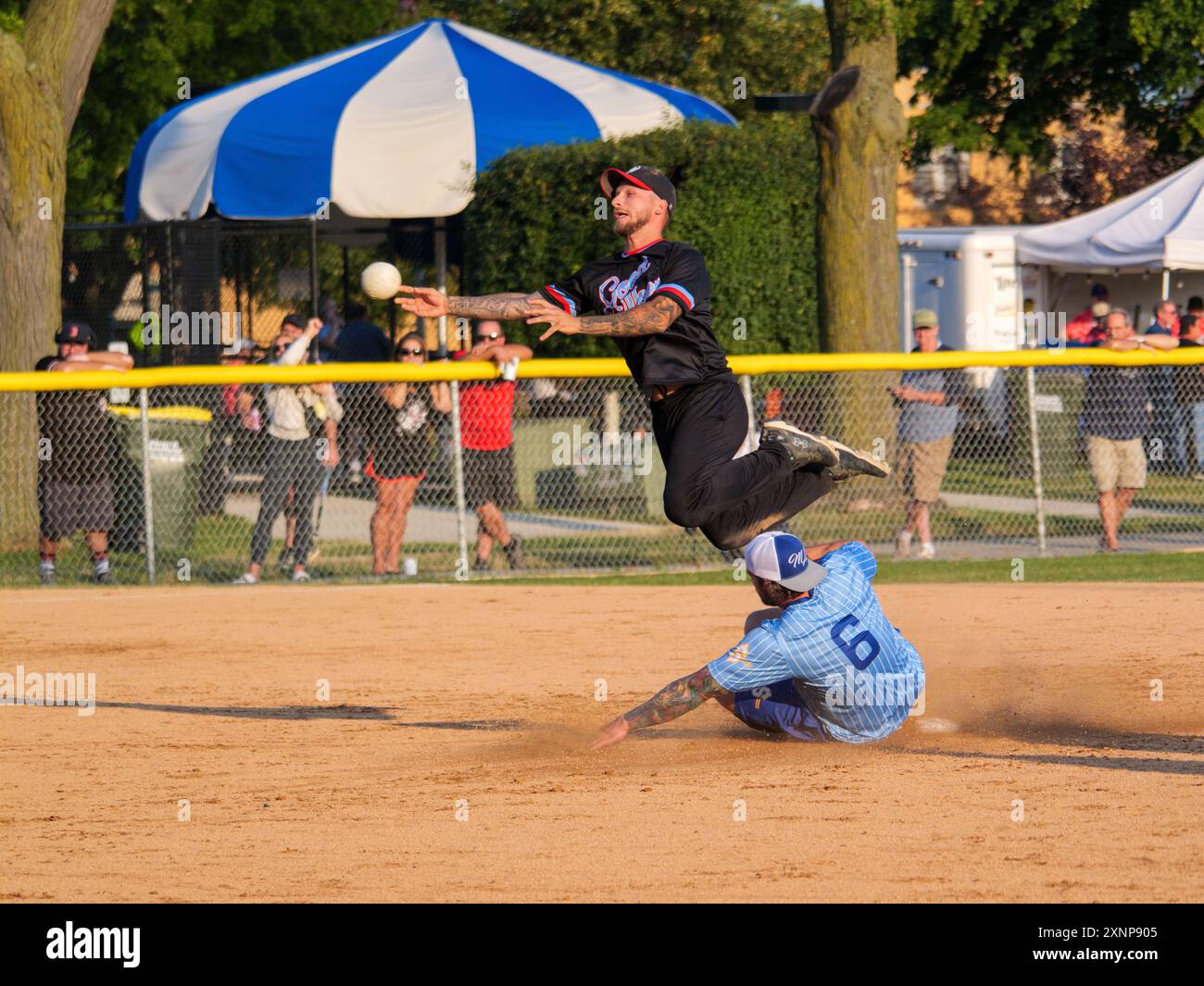 Un joueur de terrain échappe à un Baserunner tentant de rompre un double jeu lors d'un match de softball de 16 pouces, qui est populaire dans la région de Chicago. Banque D'Images