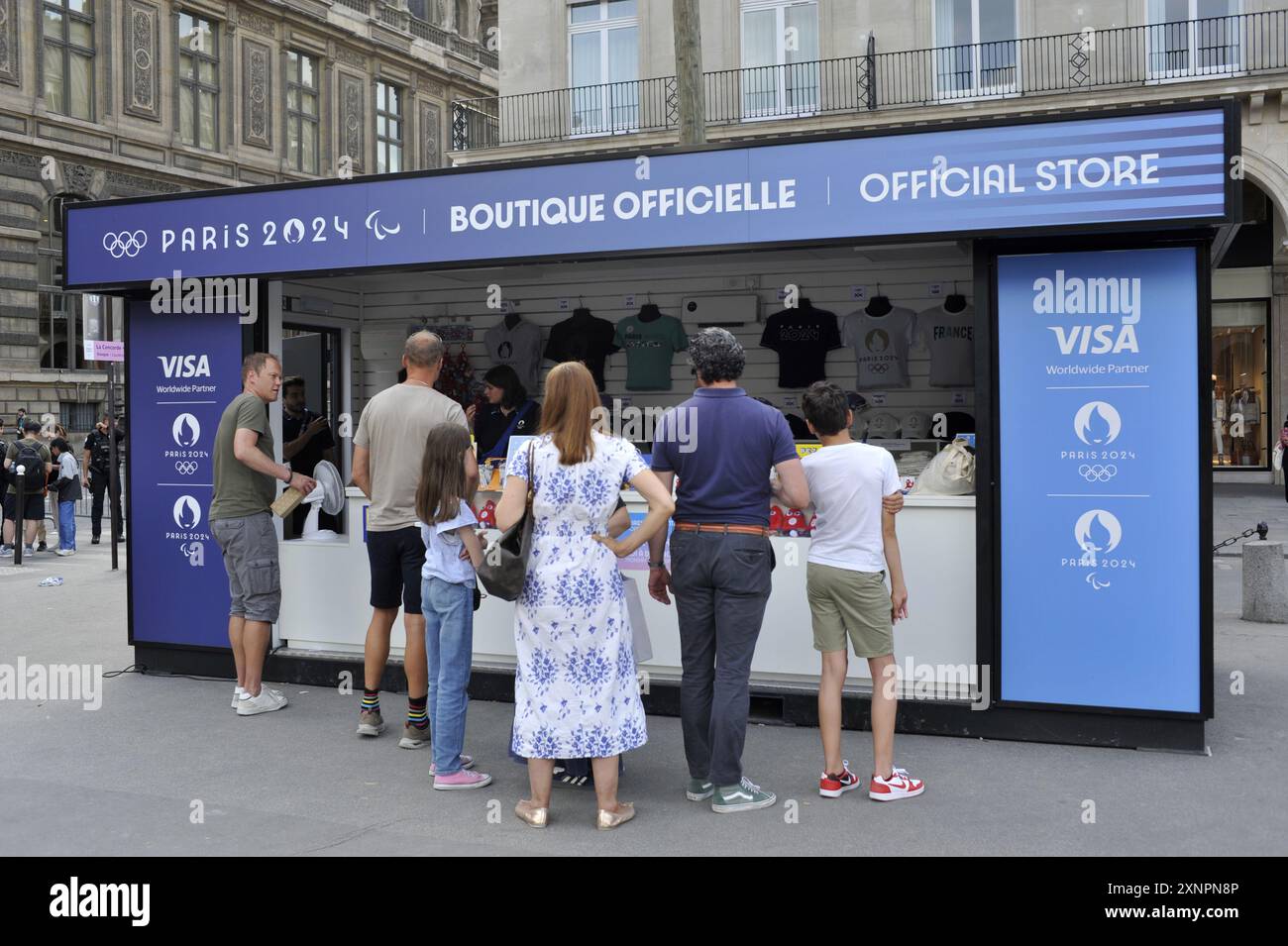 FRANCE. PARIS (75) 4E ARRONDISSEMENT. RUE DE RIVOLI . TOURISTES DEVANT UNE BOUTIQUE OFFICIELLE POUR LES JEUX OLYMPIQUES DE PARIS 2024 Banque D'Images
