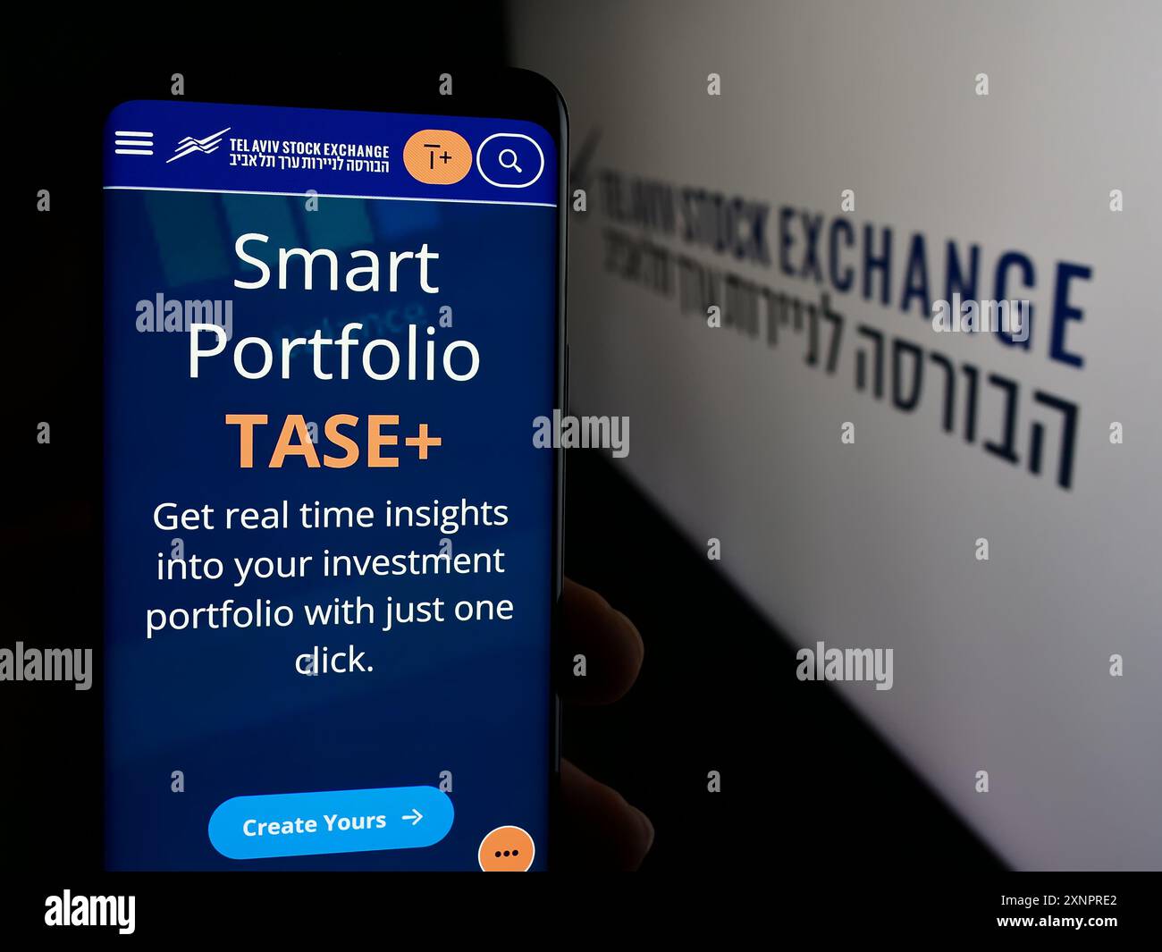 Personne tenant le téléphone portable avec la page Web de la société israélienne tel Aviv Stock Exchange (TASE) devant le logo. Concentrez-vous sur le centre de l'écran du téléphone. Banque D'Images