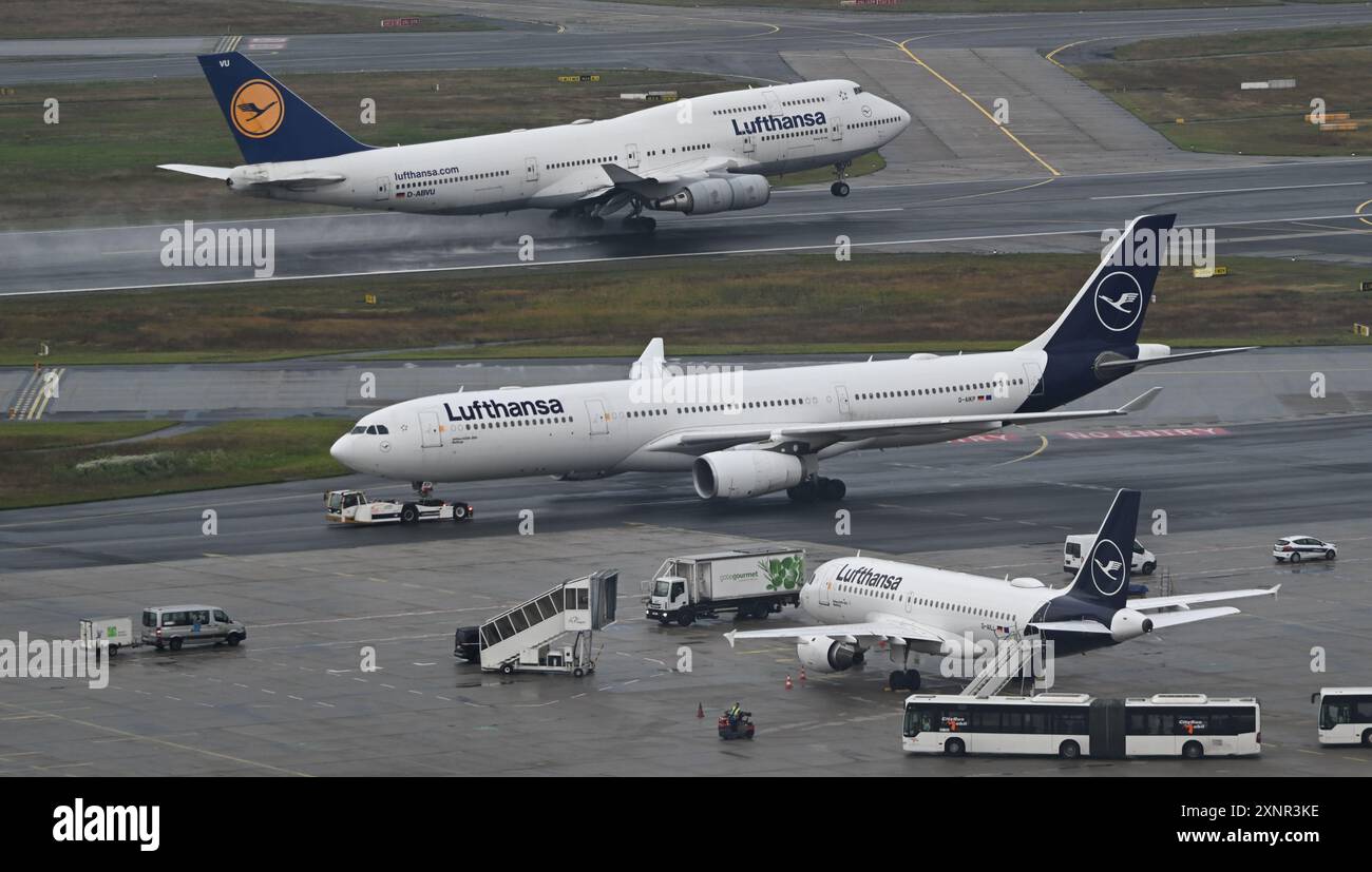 PRODUCTION - 1er août 2024, Hesse, Francfort-sur-le-main : pendant le décollage d'un Boeing 747-400 (arrière) de Lufthansa, un Airbus A330 est remorqué jusqu'au terminal 1 après l'atterrissage à l'aéroport de Francfort. Photo : Arne Dedert/dpa Banque D'Images