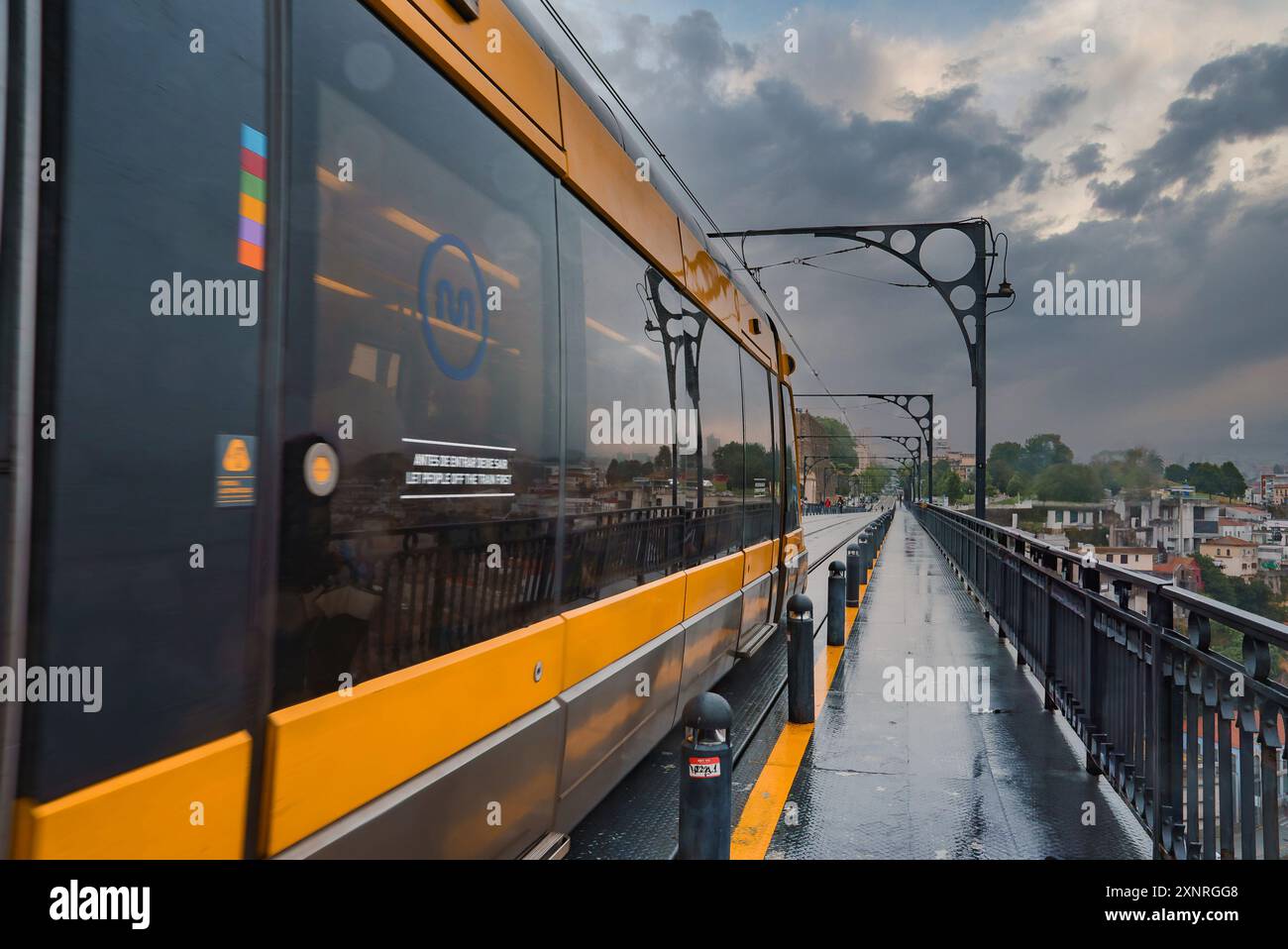 Train de métro jaune sur le pont Dom Luis I à Porto un jour couvert Banque D'Images