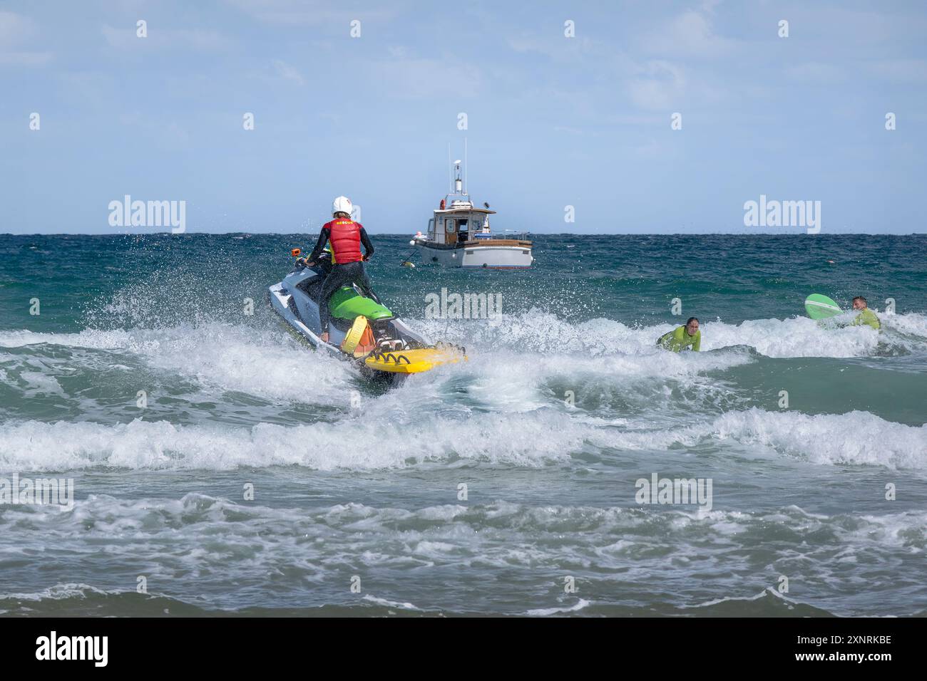 Un sauveteur de la RNLI Royal National Lifeboat institution patrouillant au large de Towan Beach en jet ski sur la côte de Newquay en Cornouailles au Royaume-Uni. Banque D'Images