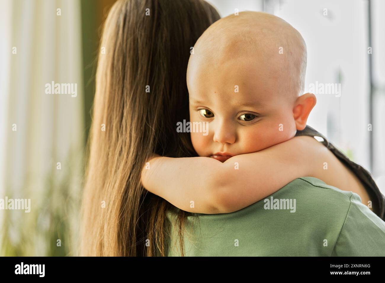 Jeune femme avec prothèse tenant bébé garçon étroitement Banque D'Images