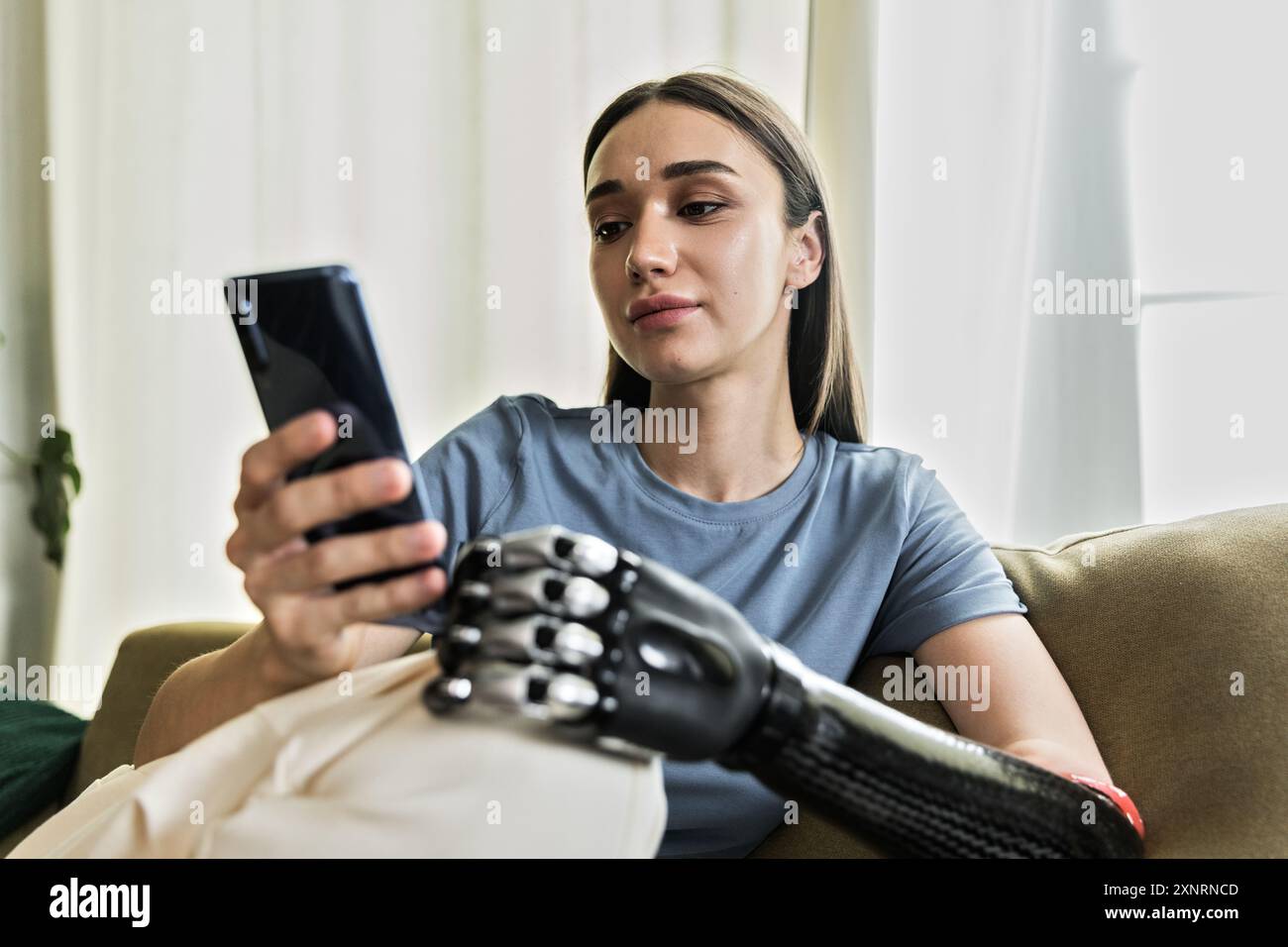 Jeune femme avec prothèse utilisant le téléphone portable Banque D'Images