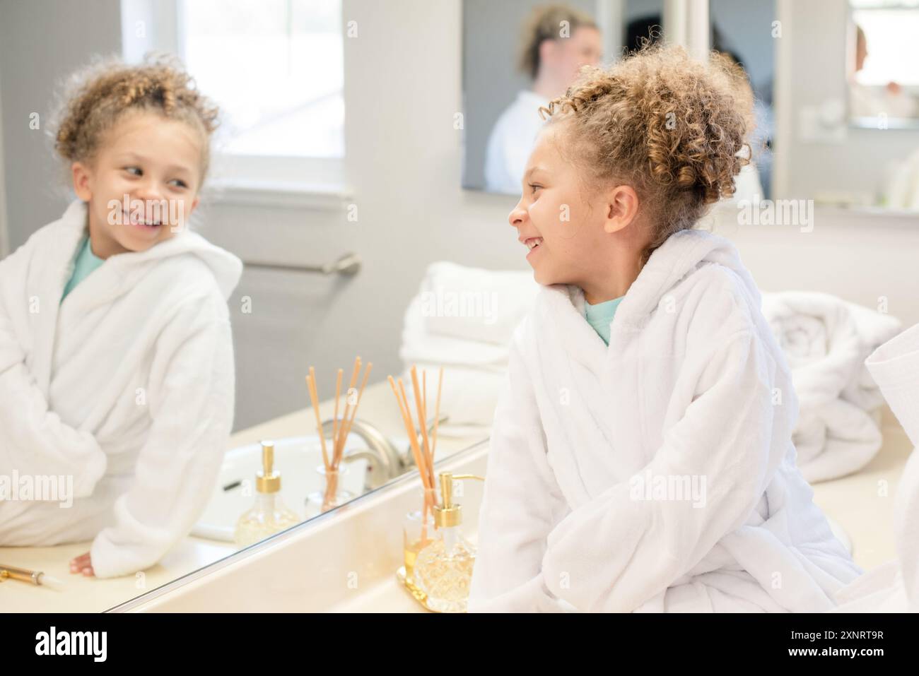 La petite fille regarde son reflet dans le miroir Banque D'Images