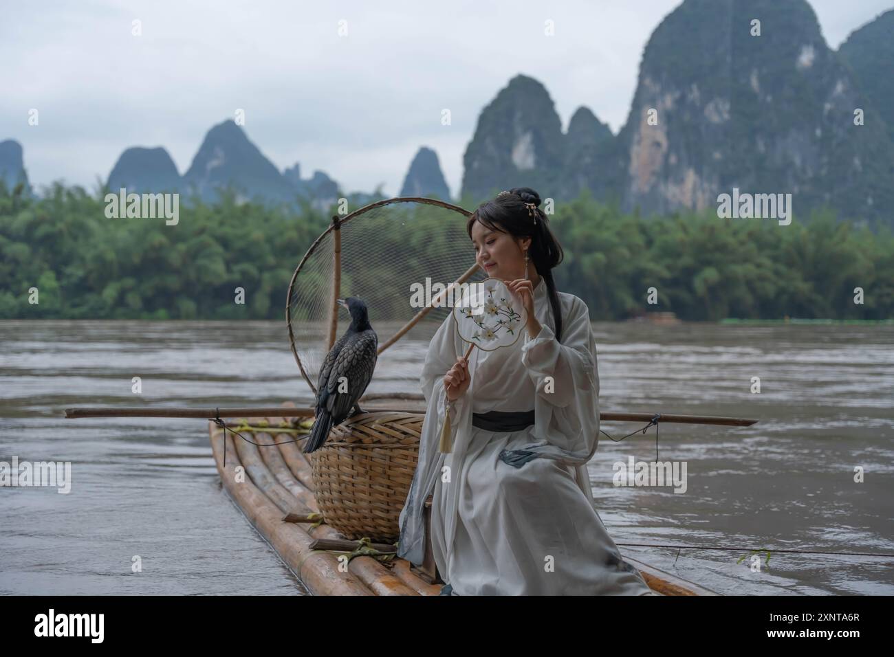 Jeune femme chinoise Hanfu regardant vers le bas le radeau de bambou près de la rivière Li à Xingping. Gros plan Banque D'Images