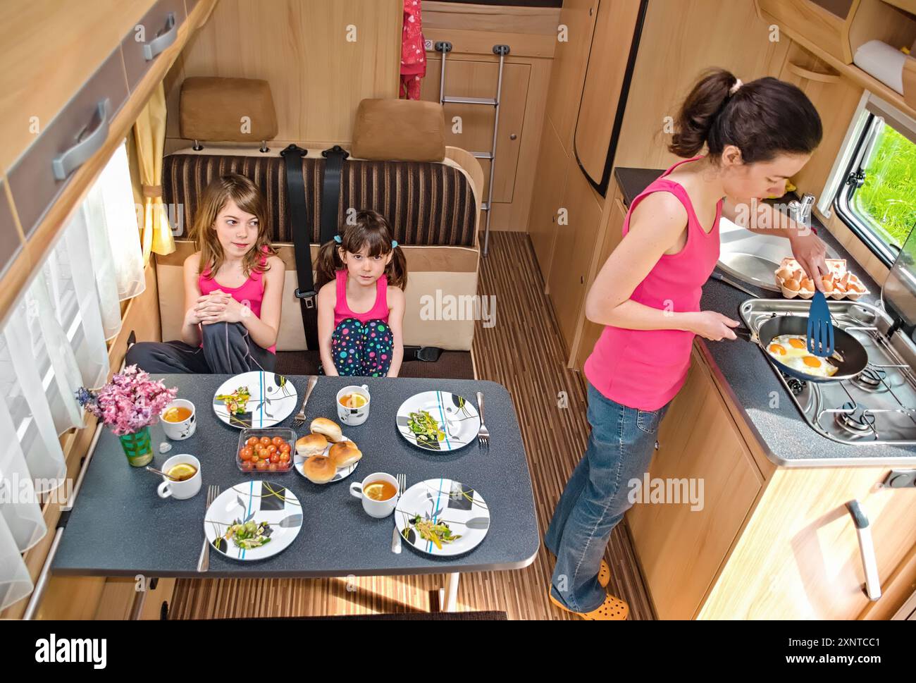 Famille mangeant ensemble à l'intérieur du RV, mère et enfants voyagent en camping-car (camping-car, caravane) en vacances en famille avec enfants Banque D'Images