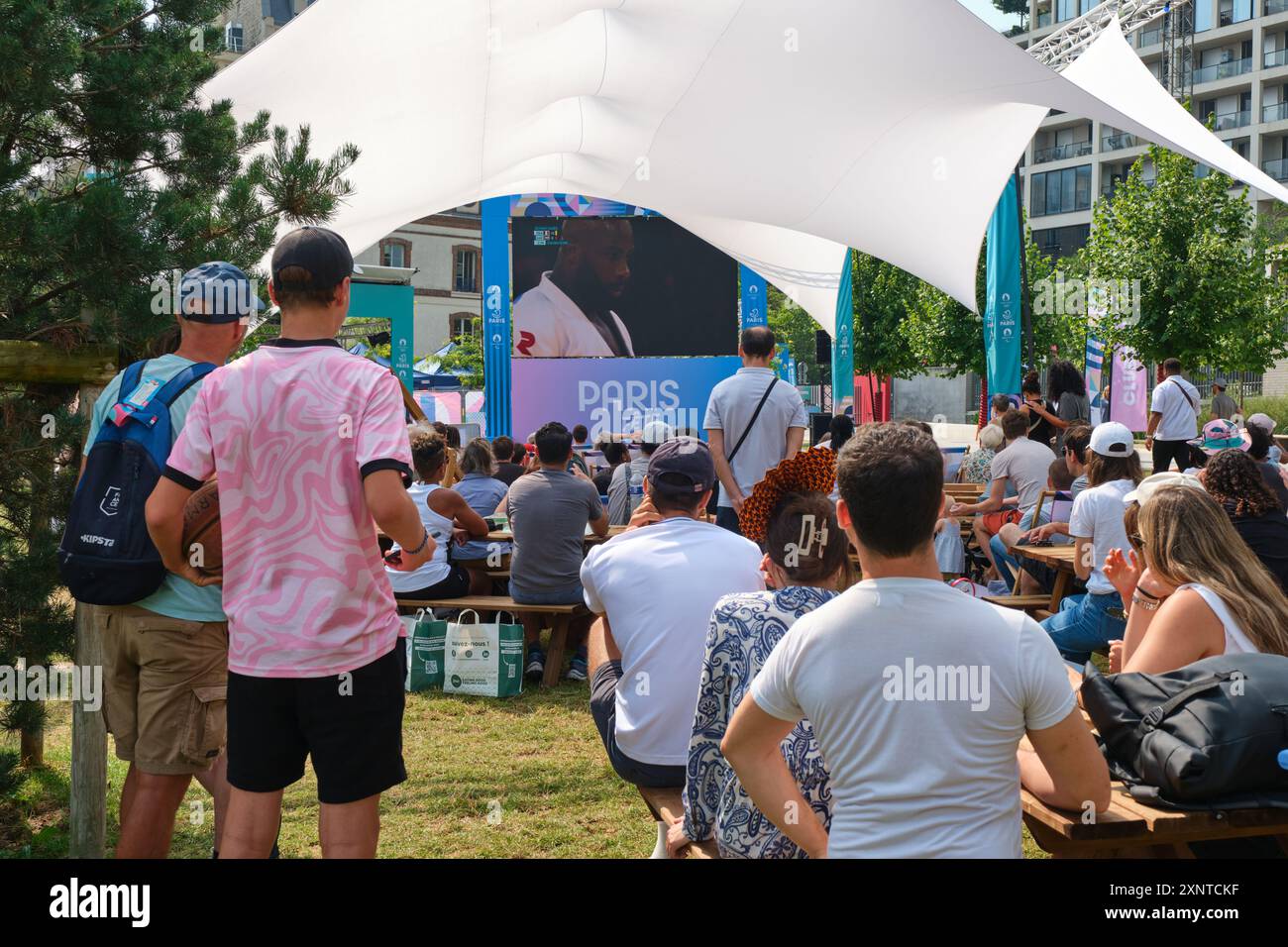 Zone fan des Jeux Olympiques de Paris 2024 dans le Parc Clichy Batignolles Martin Luther-King (17ème arrondissement). Les gens regardant les Jeux olympiques d'été sur grand écran Banque D'Images