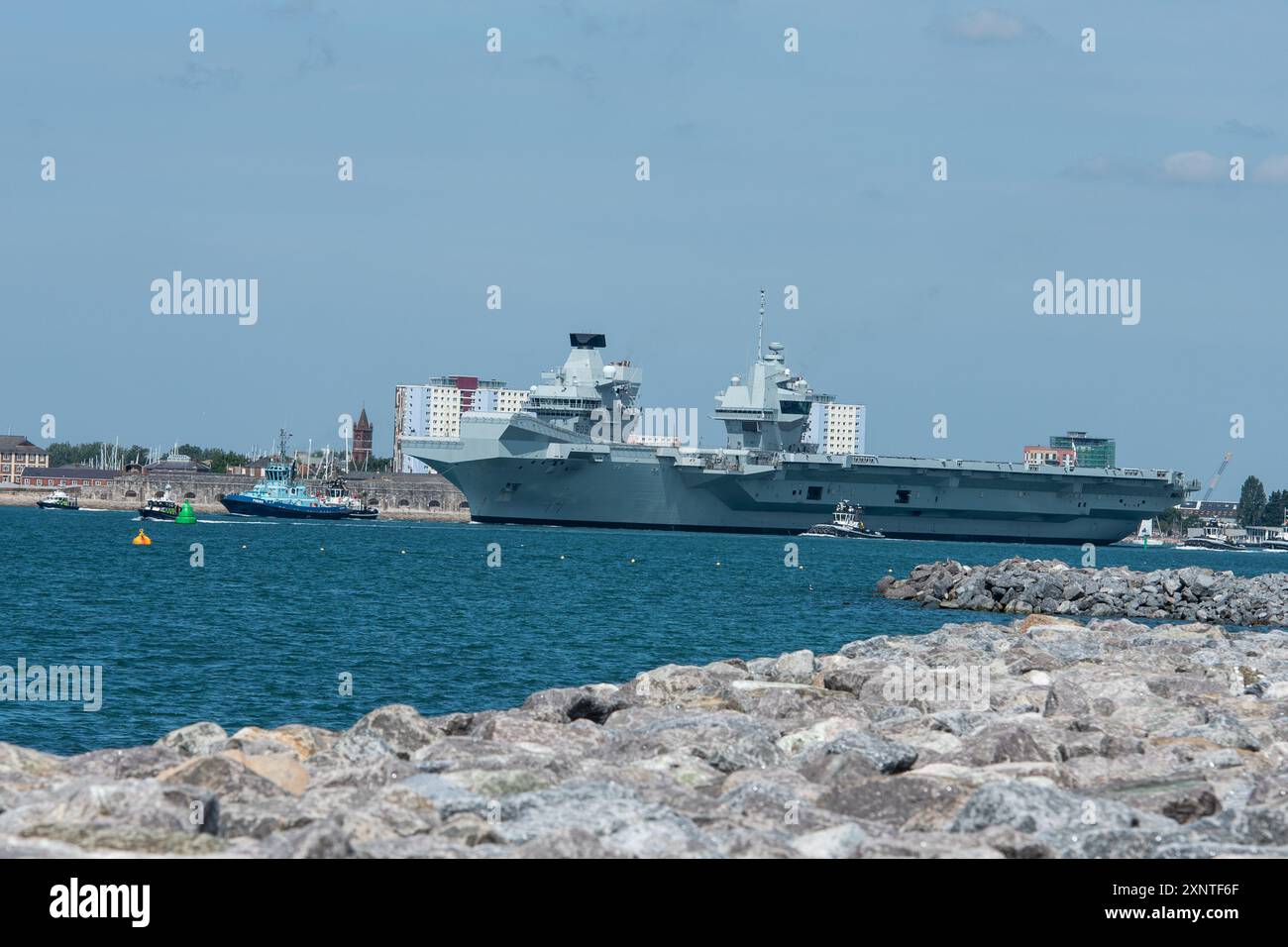 Le HMS Prince of Wales avec ses remorqueurs et son escorte policière, quitte Portsmouth le vendredi 2 août 2024 pour Glen Mallan en Écosse pour ammunitionner en prévision des opérations futures. Crédit Emma Terracciano/Alamy Live News Banque D'Images