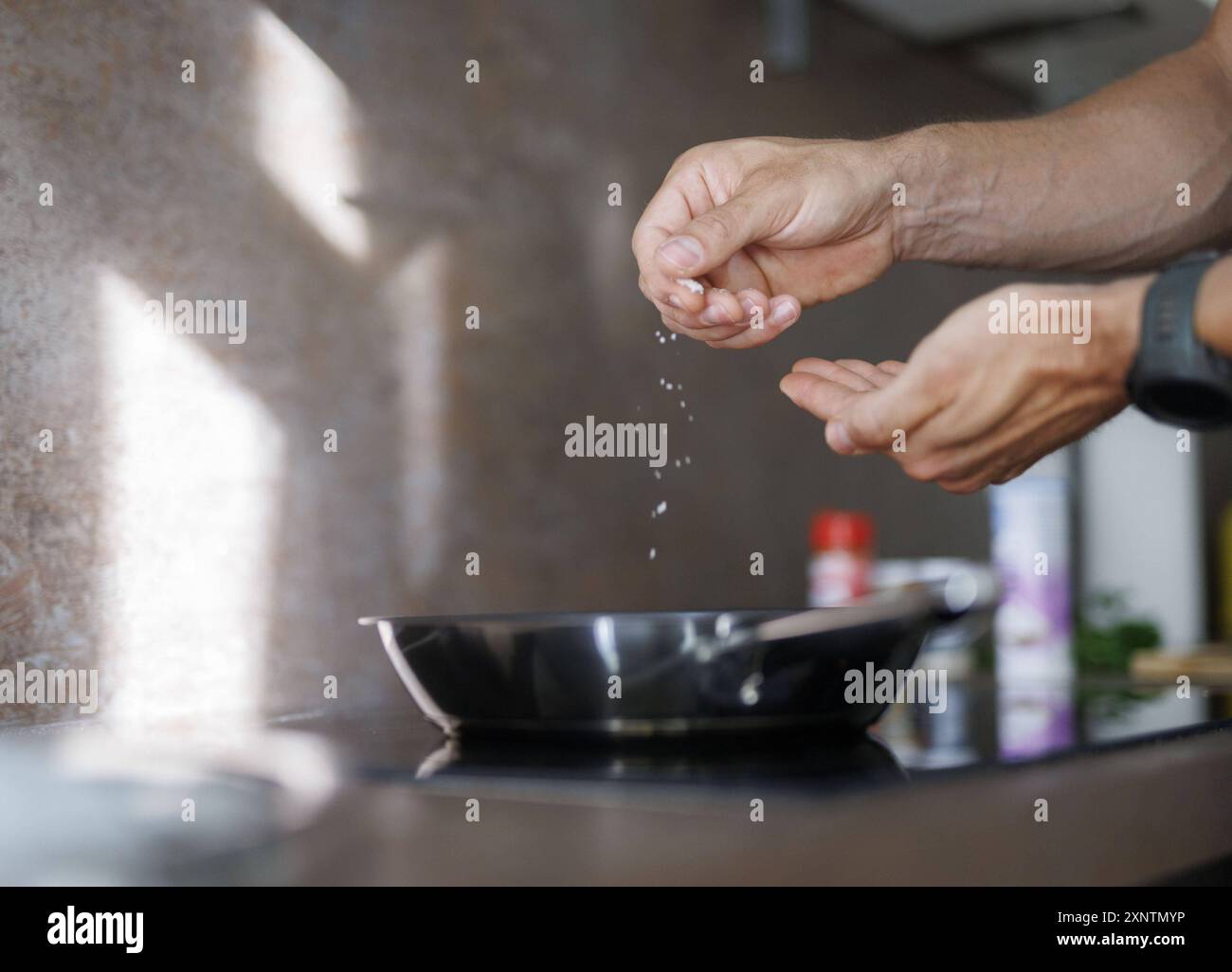 Thema kochen. Ein Mann salzt ein Gericht in einer Pfanne. Berlin, 01.08.2024. Berlin Deutschland *** sujet cuisiner Un homme salant un plat dans une casserole Berli Banque D'Images