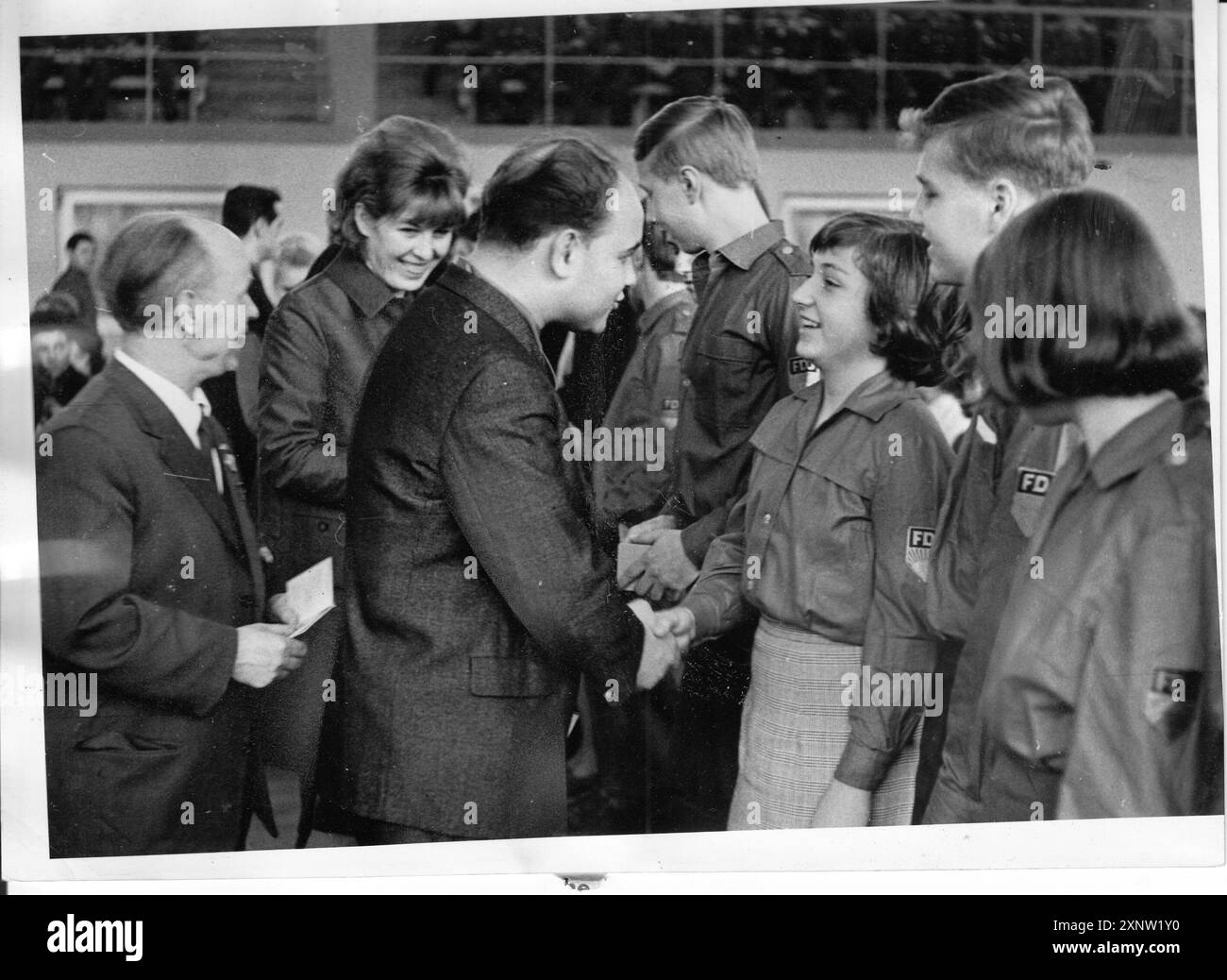 Événement festif dans la salle de sport Heinrich-Mann-Allee pour marquer le 20e anniversaire de la Jeunesse allemande libre (FDJ). Manfred Presch, 1er secrétaire de la direction du district de la FDJ, présente le livre des membres de la FDJ aux jeunes lors de la cérémonie. Événement. DDR.historiquement. Photo : MAZ/Herbert Dörries, 08.03.1966 [traduction automatique] Banque D'Images