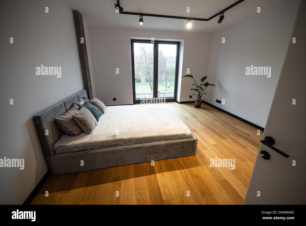 Chambre avec un grand lit confortable. Intérieur d'une maison nouvellement construite, chambre avec un grand lit confortable avec des oreillers moelleux et des draps moelleux, compl Banque D'Images