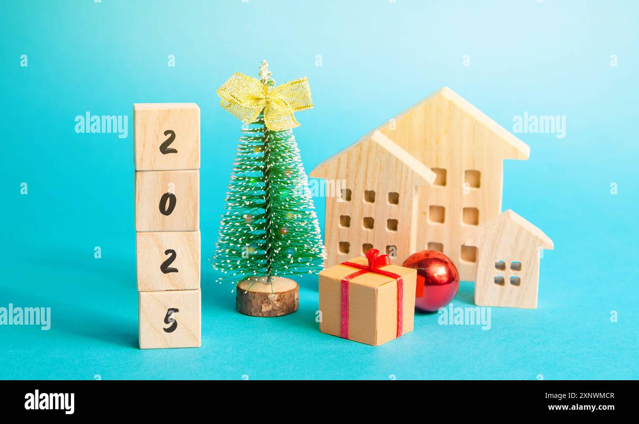 Blocs de bois 2025, arbre de Noël et de nombreuses maisons. Nouvel an et Noël vacances d'hiver. Le concept du début de la nouvelle année. Fond bleu. D Banque D'Images