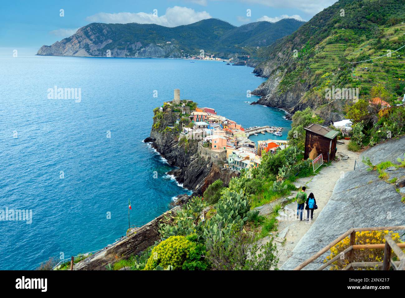 Deux touristes approchent Vernazza, une ville côtière dans la province de la Spezia, région des Cinque Terre, site du patrimoine mondial de l'UNESCO, Ligurie, Italie, Europe Banque D'Images