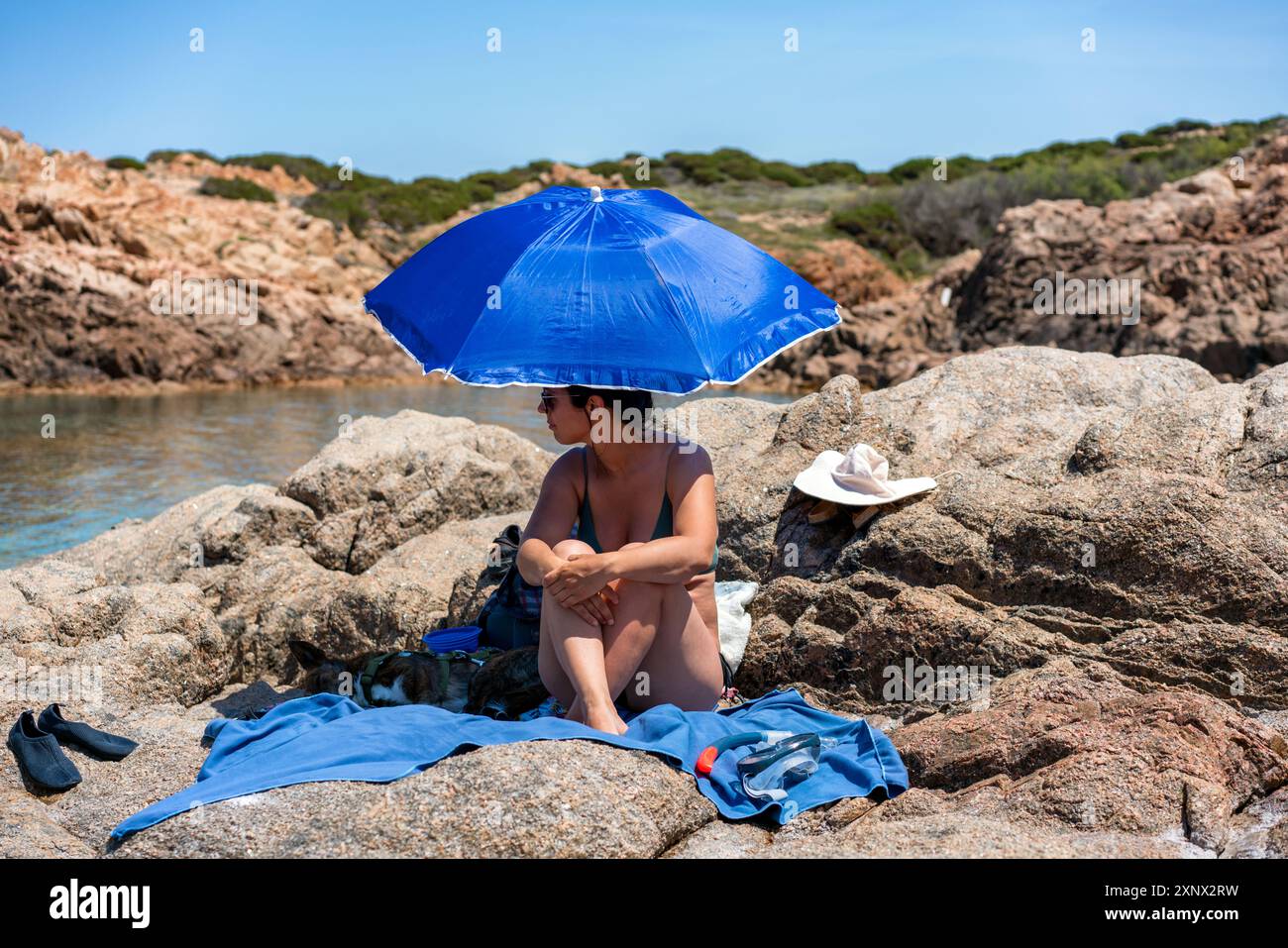Femme avec chien sous un parasol sur une plage, Sardaigne, Italie, Méditerranée, Europe Banque D'Images