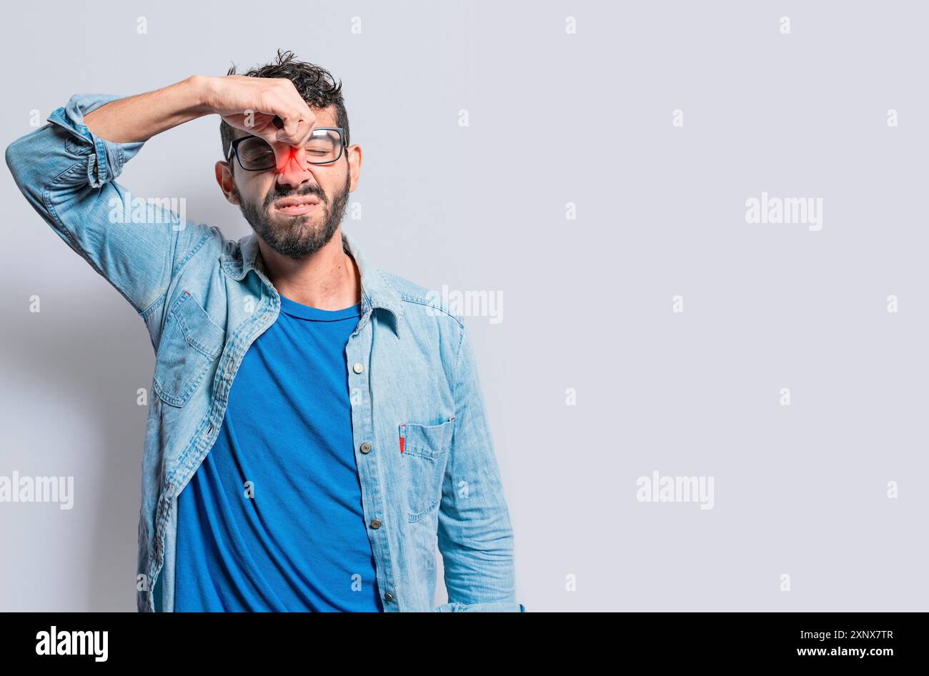 Une personne avec une douleur de pont nasal. Homme avec maux de tête de pont nasal, personne avec douleur touchant le nez. Notion de douleur sinusale Banque D'Images