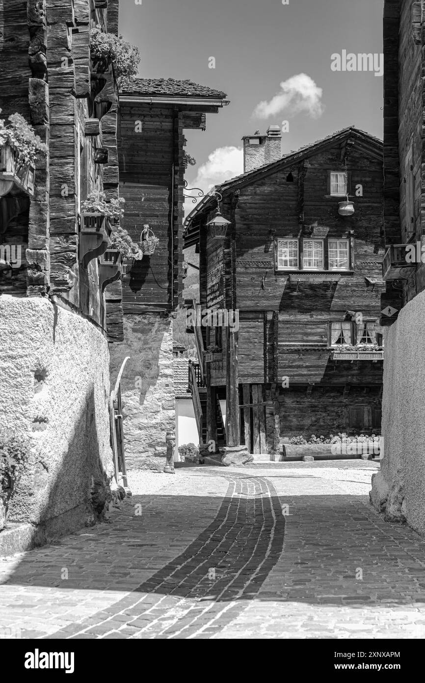 Sentier pavé entouré de vieilles maisons en bois, centre historique du village, photographie en noir et blanc, Grimentz, Val d'Anniviers, Alpes valaisannes, Canton Banque D'Images