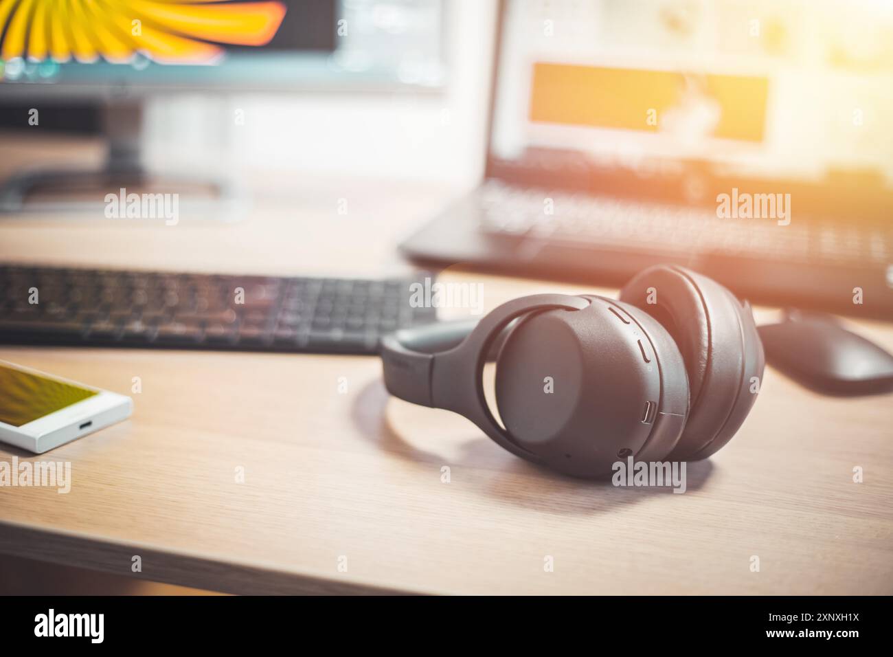 Casque noir sans fil, souris et clavier sur un bureau en bois Banque D'Images