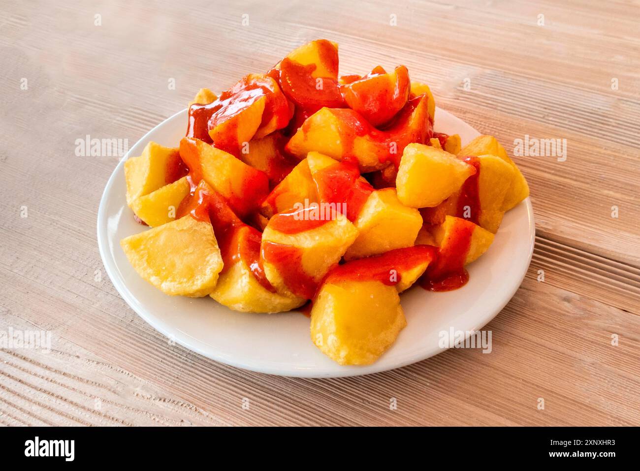 Patatas bravas, cuisine espagnole typique. Pomme de terre avec une sauce épicée, sur une table en bois Banque D'Images