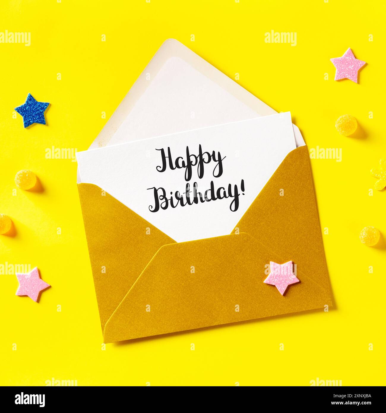 Carte d'anniversaire dans une enveloppe dorée, photo carrée sur fond jaune avec étoiles brillantes Banque D'Images