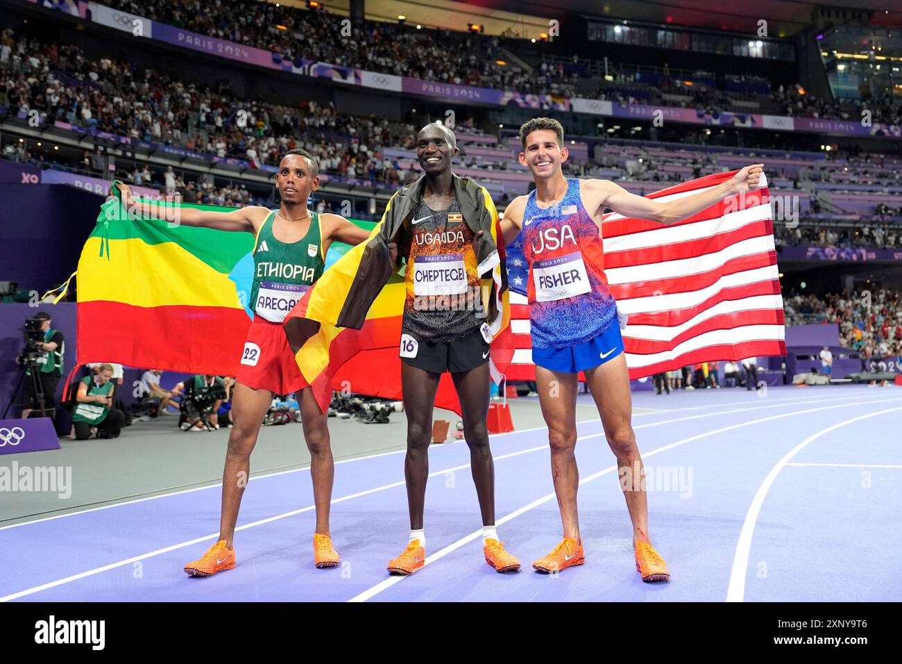 Silver medalist Berihu Aregawi, from left, of Ethiopia, gold medalist Joshua Cheptegei, of Uganda, and bronze medalist Grant Fisher, right, of the United States, pose after the men's 10000 meters final at the 2024 Summer Olympics, Friday, Aug. 2, 2024, in Saint-Denis, France. (AP Photo/Matthias Schrader) Banque D'Images