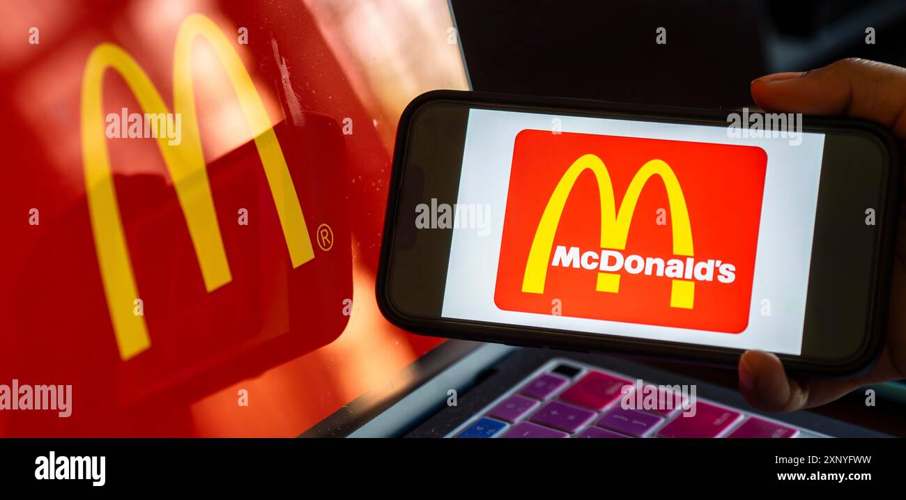 Dans cette illustration photo, le logo McDonald's est affiché sur un smartphone avec un arrière-plan d'écran d'ordinateur portable. Les ventes de McDonald's chutent pour la première fois dans le monde Banque D'Images