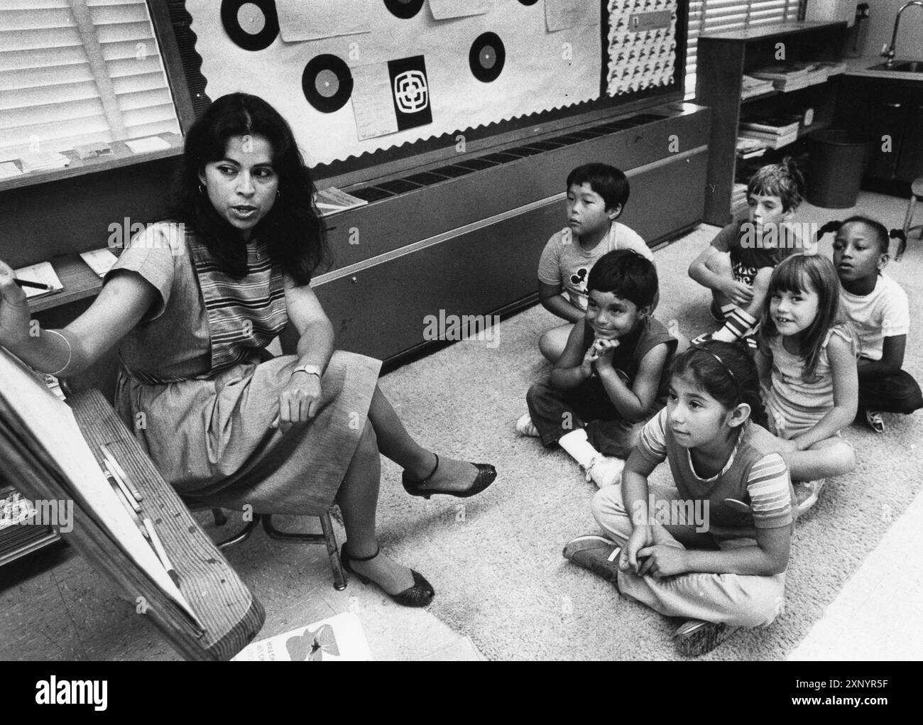 Austin Texas USA, 1992 : enseignant bilingue de l'éducation lisant une histoire aux élèves de deuxième année alors qu'ils sont assis sur le sol devant elle. ©Bob Daemmrich Banque D'Images