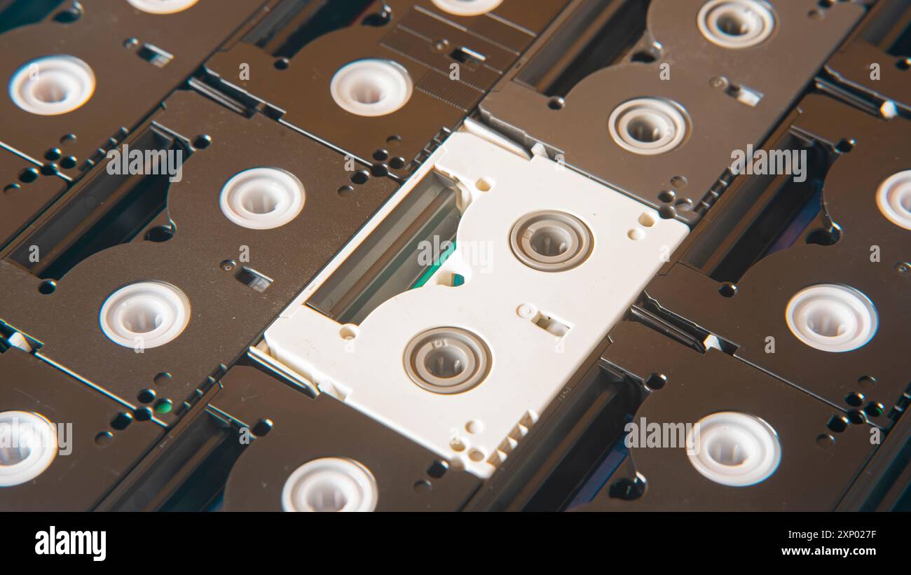 Fond de vieilles mini cassettes DV noires entourant une cassette blanche Banque D'Images