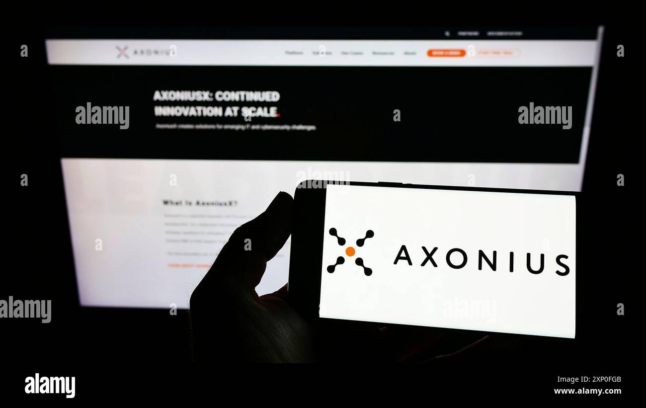 Stuttgart, Allemagne, 03-12-2013 2022 : personne tenant un smartphone avec le logo de la société américaine de cybersécurité Axonius Inc sur l'écran devant le site Web. Concentrez-vous sur Banque D'Images