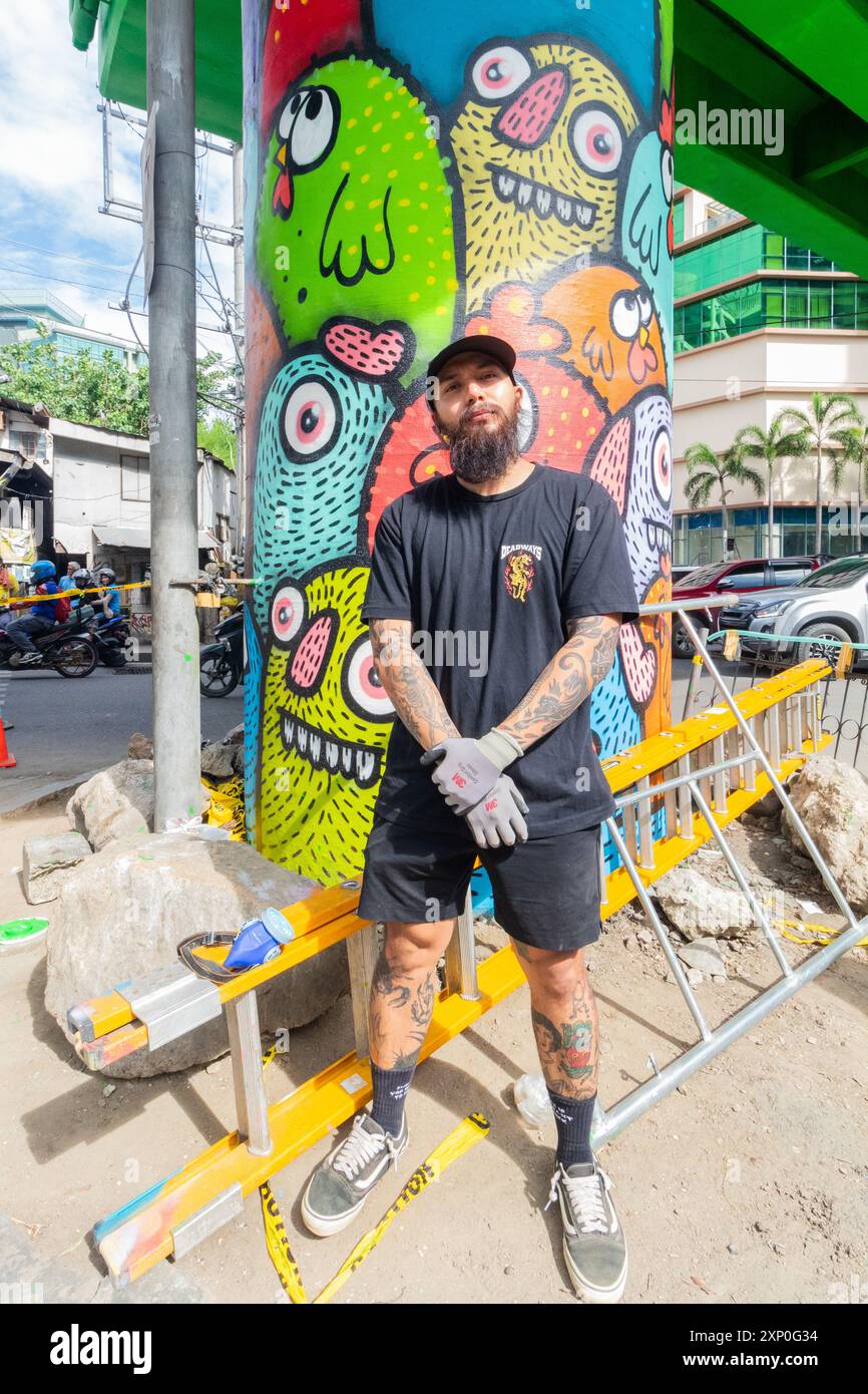 Le Street artiste philippin Distort Monsters devant son travail à Cebu City, Philippines Banque D'Images