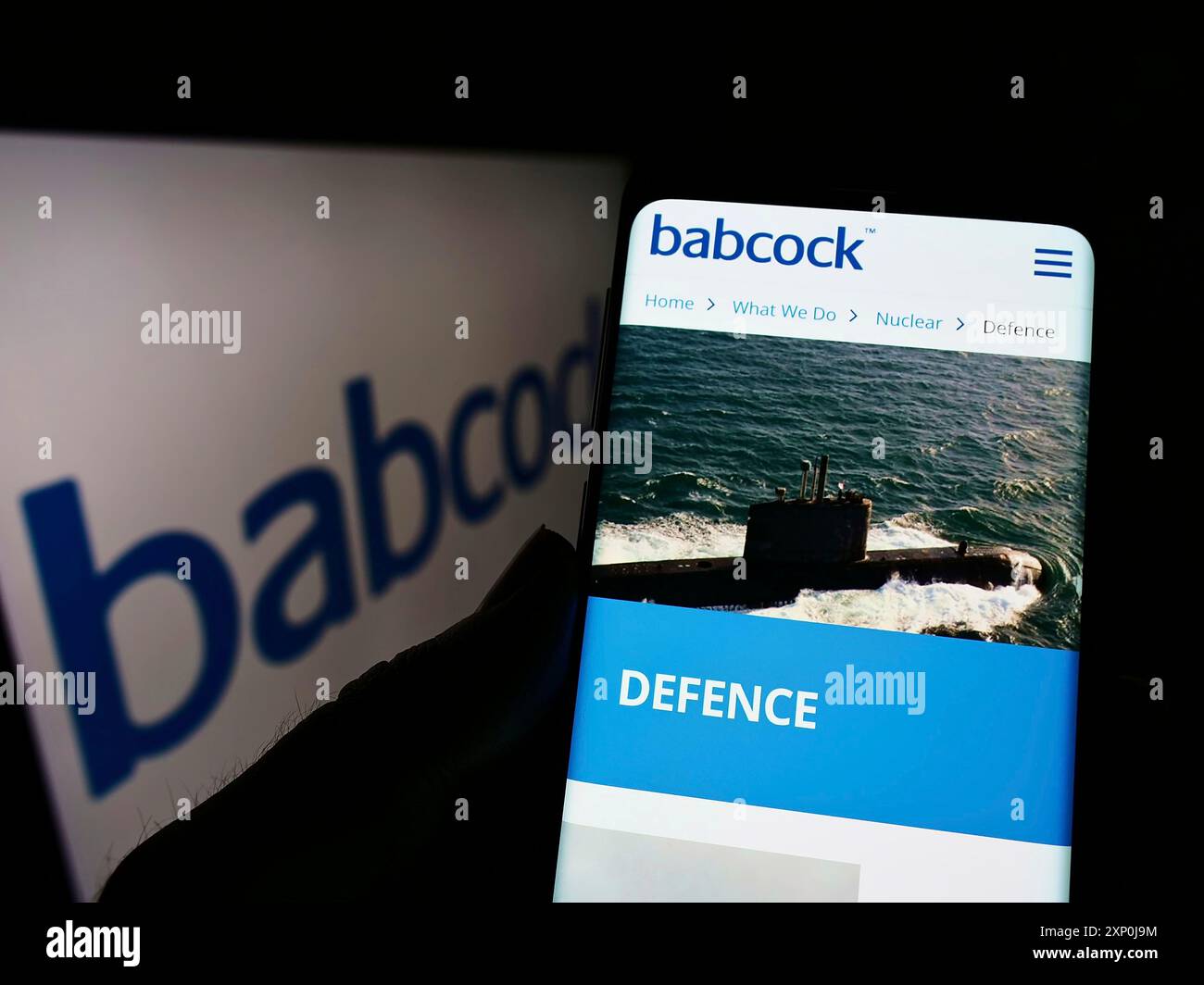 Stuttgart, Allemagne, 01-30-2022, personne tenant le téléphone portable avec la page web de la société britannique Babcock International Group plc sur l'écran avec le logo. Mise au point Banque D'Images