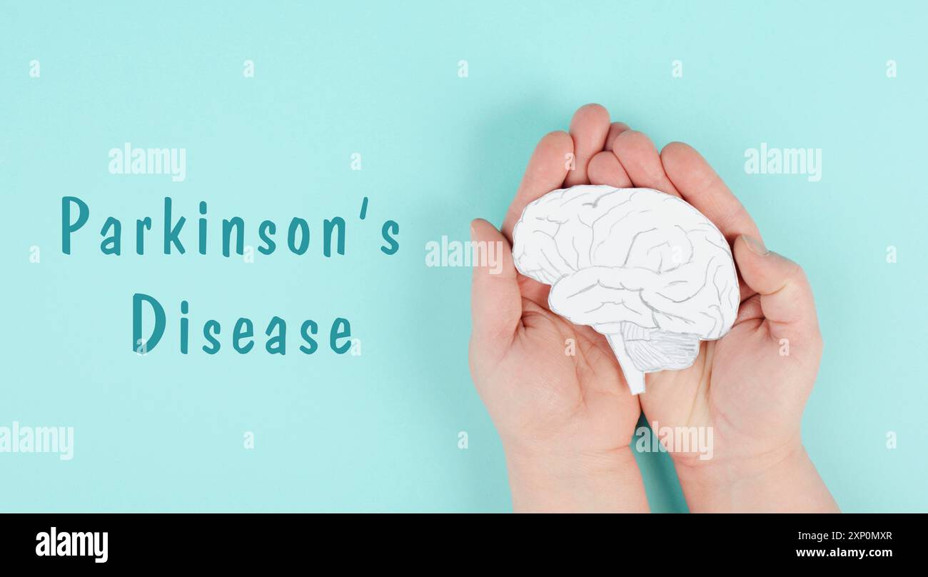 La maladie de Parkinson se trouve sur un papier, les mains tenant le cerveau, le diagnostic de démence, la maladie d'Alzheimer Banque D'Images