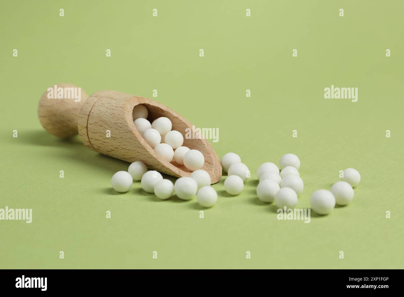 Scoop avec remède homéopathique sur fond vert clair Banque D'Images