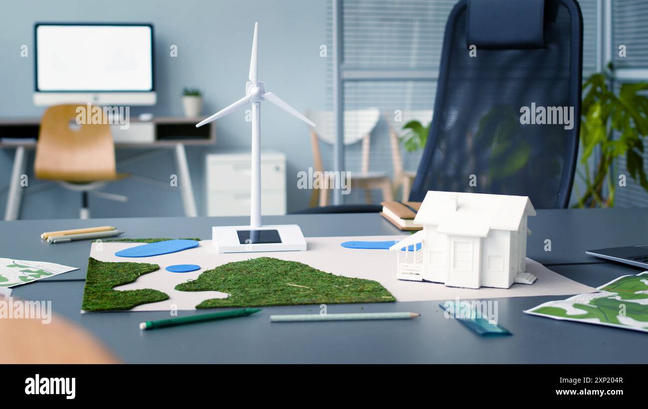 Lieu de travail de l'ingénieur avec moniteur d'ordinateur et modèle d'éolienne dans le bureau. Modèles et diagrammes d'éoliennes. Parfait pour illustrer les sujets Banque D'Images