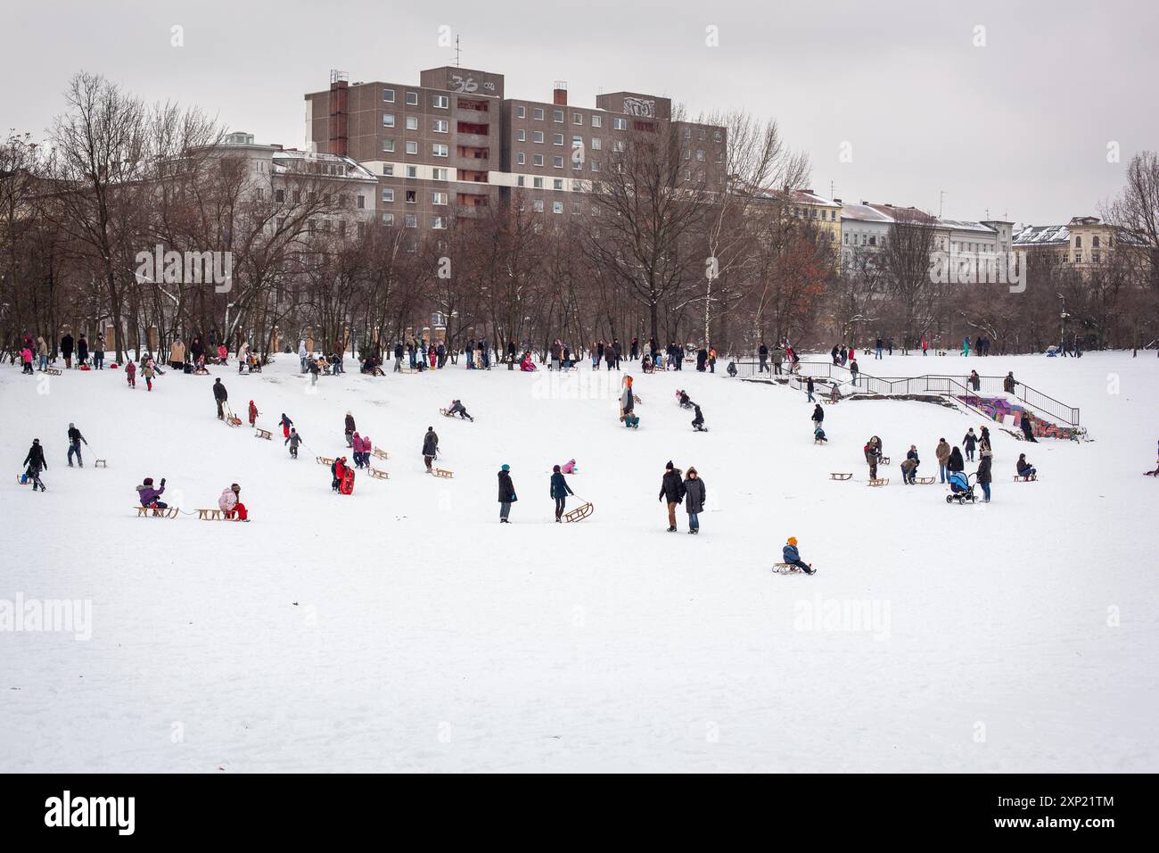 Une scène hivernale animée avec des gens en luge dans le parc Görlitzer, Kreuzberg, Berlin. Les familles et les amis apprécient la neige. Banque D'Images