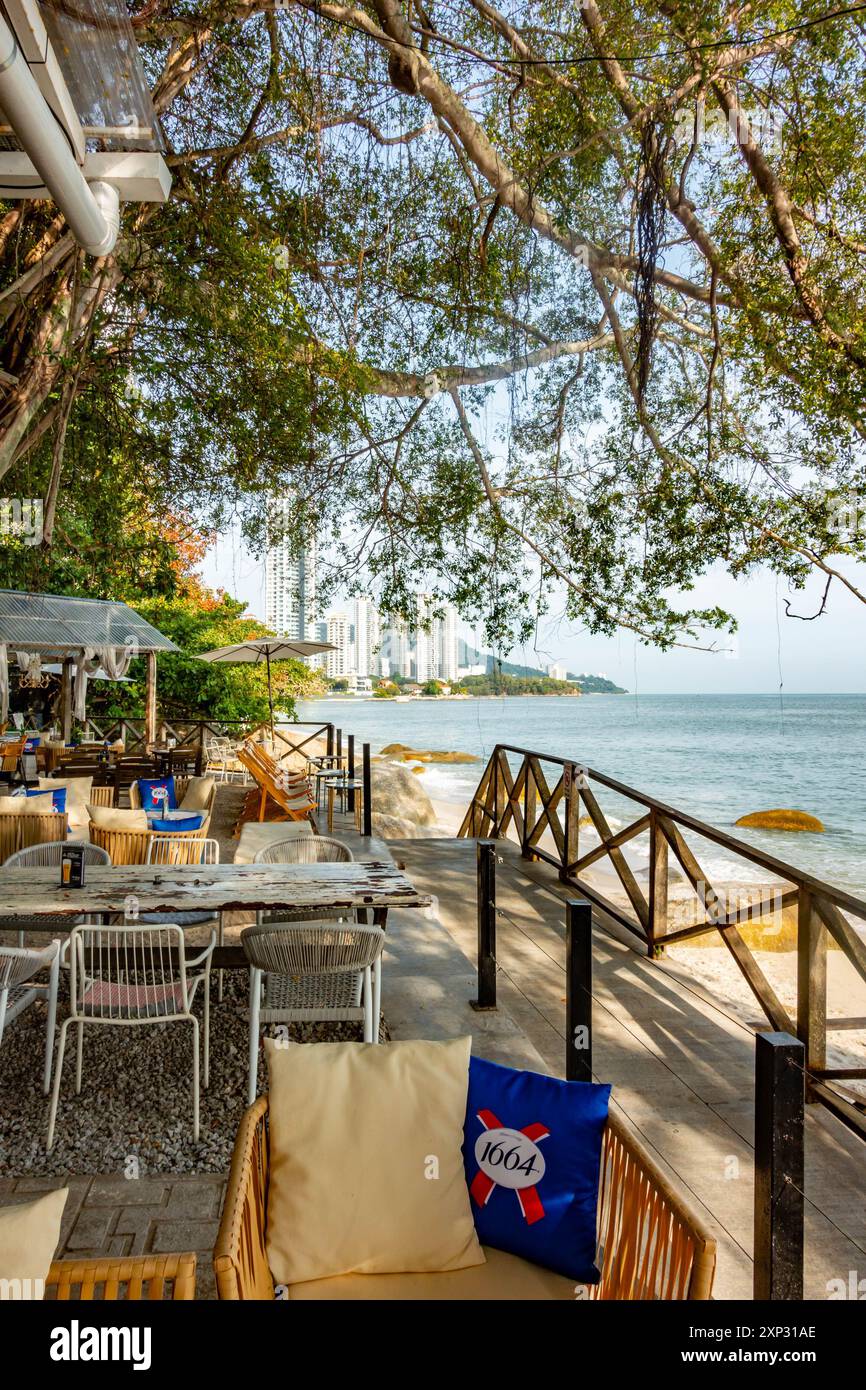 Tables et chaises dans un restaurant avec vue sur la plage de Tanjing Tokong à Penang, Malaisie Banque D'Images