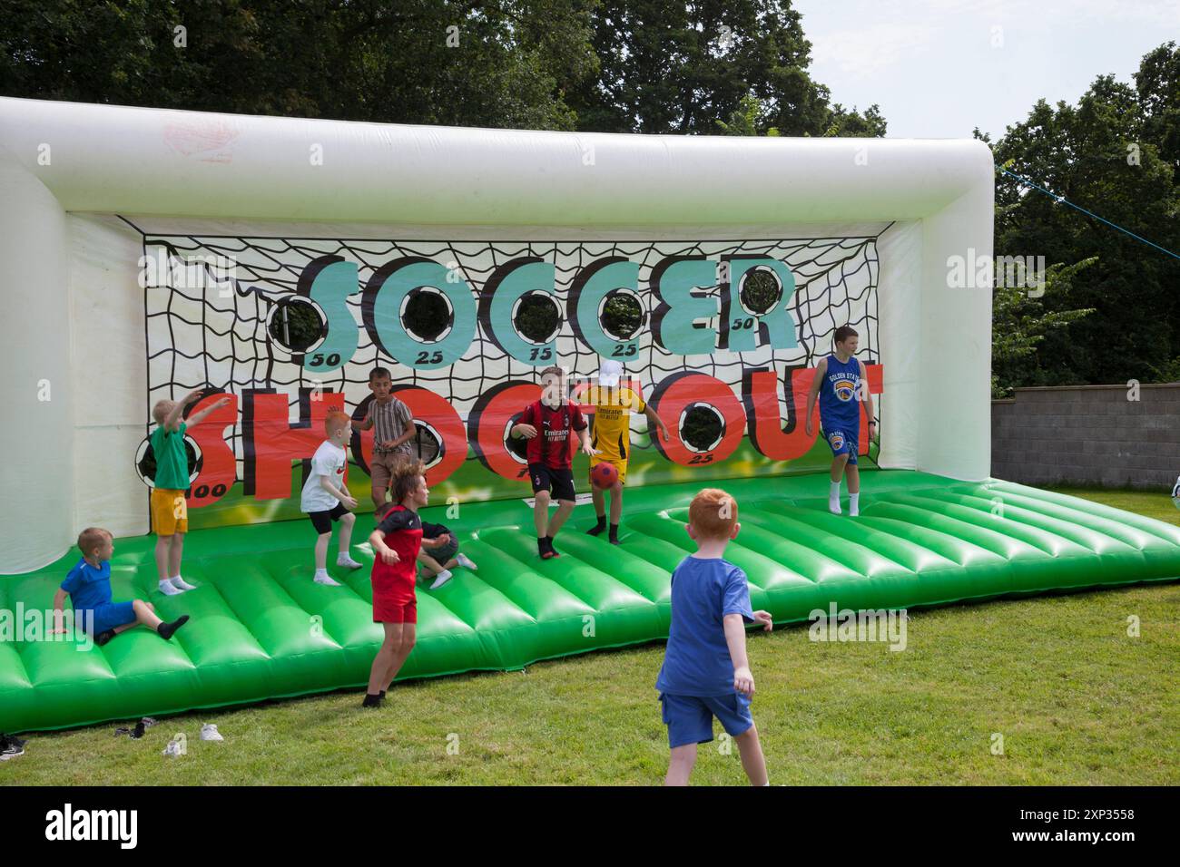 Garçons jouant au football au Soccer Shoot Out. Banque D'Images